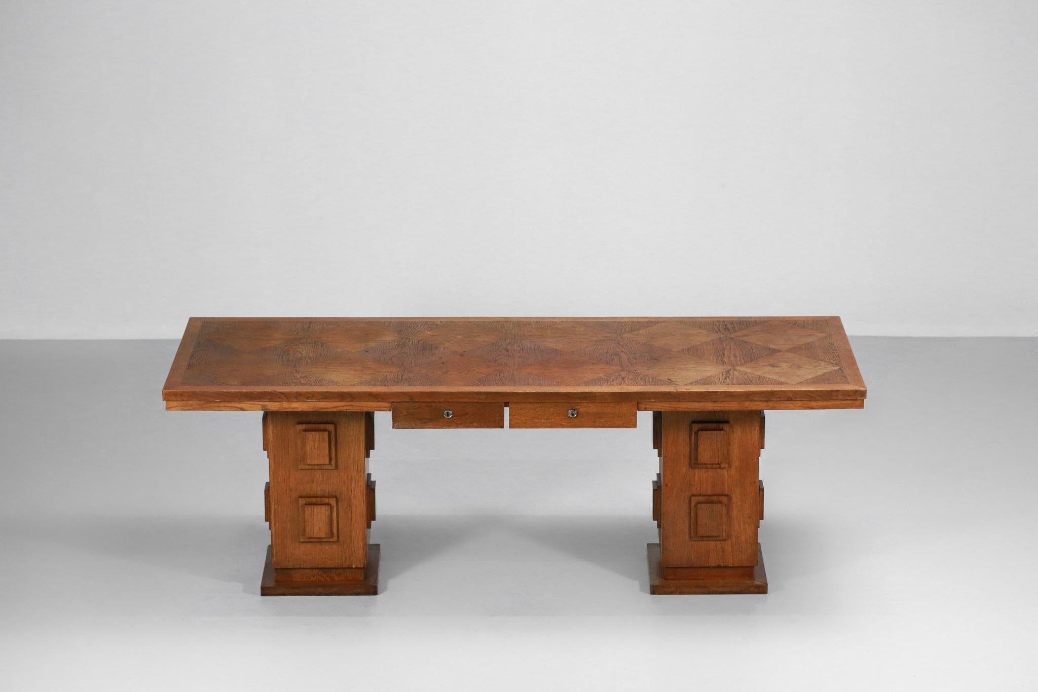 French desk from the 1950s in solid oak and veneer.
It can also be used as a dining table and the legs are adjustable.
It has two suspended drawers and the top is inlaid in the shape of a large checkerboard.
Traces of use ( cf photos )