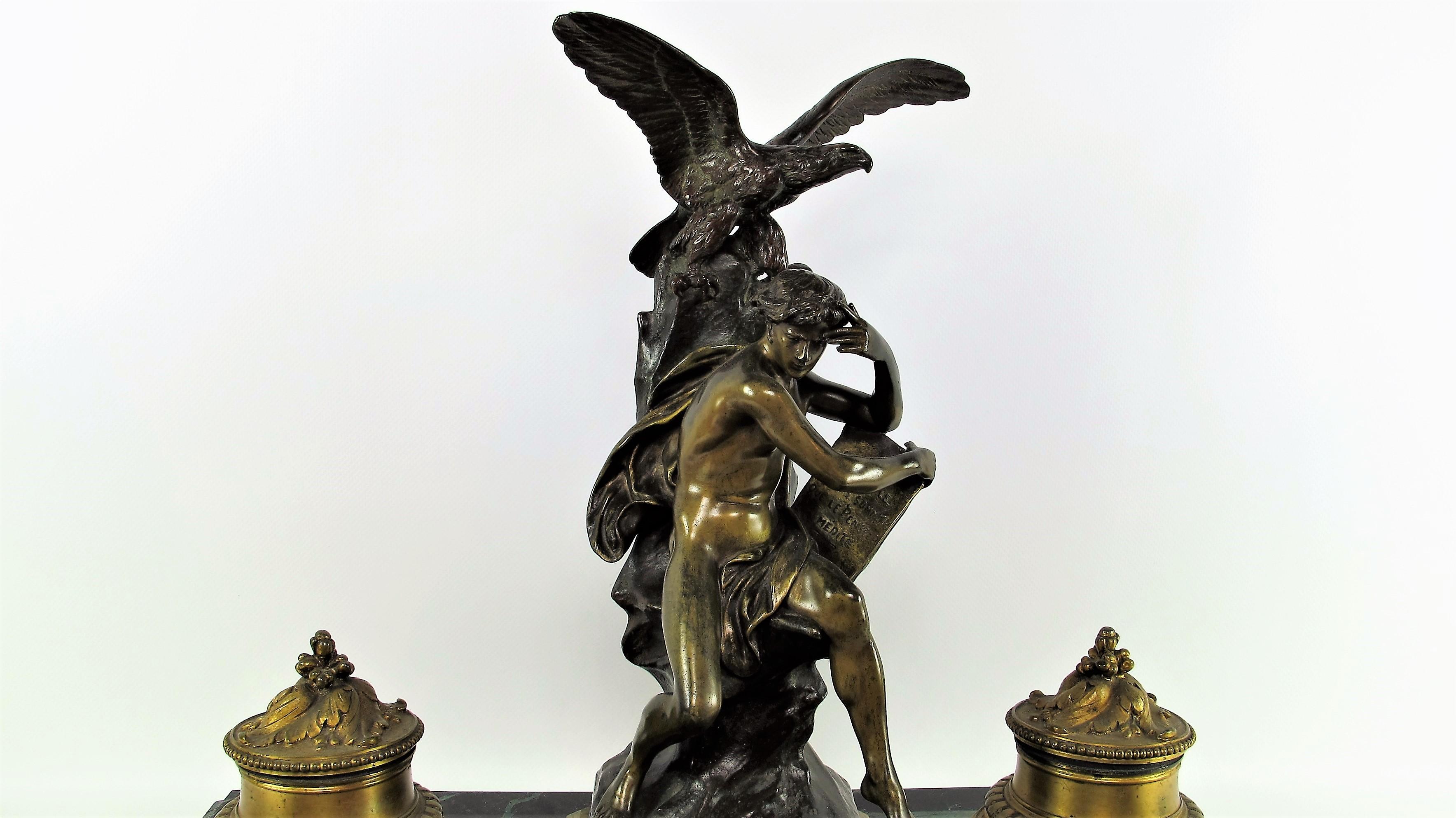 Important bronze inkwell with polychrome patina on a sea green marble plinth. Allegorical bronze titled and signed on the base. The young man sits on a rock with an eagle, and holds a marked book: 