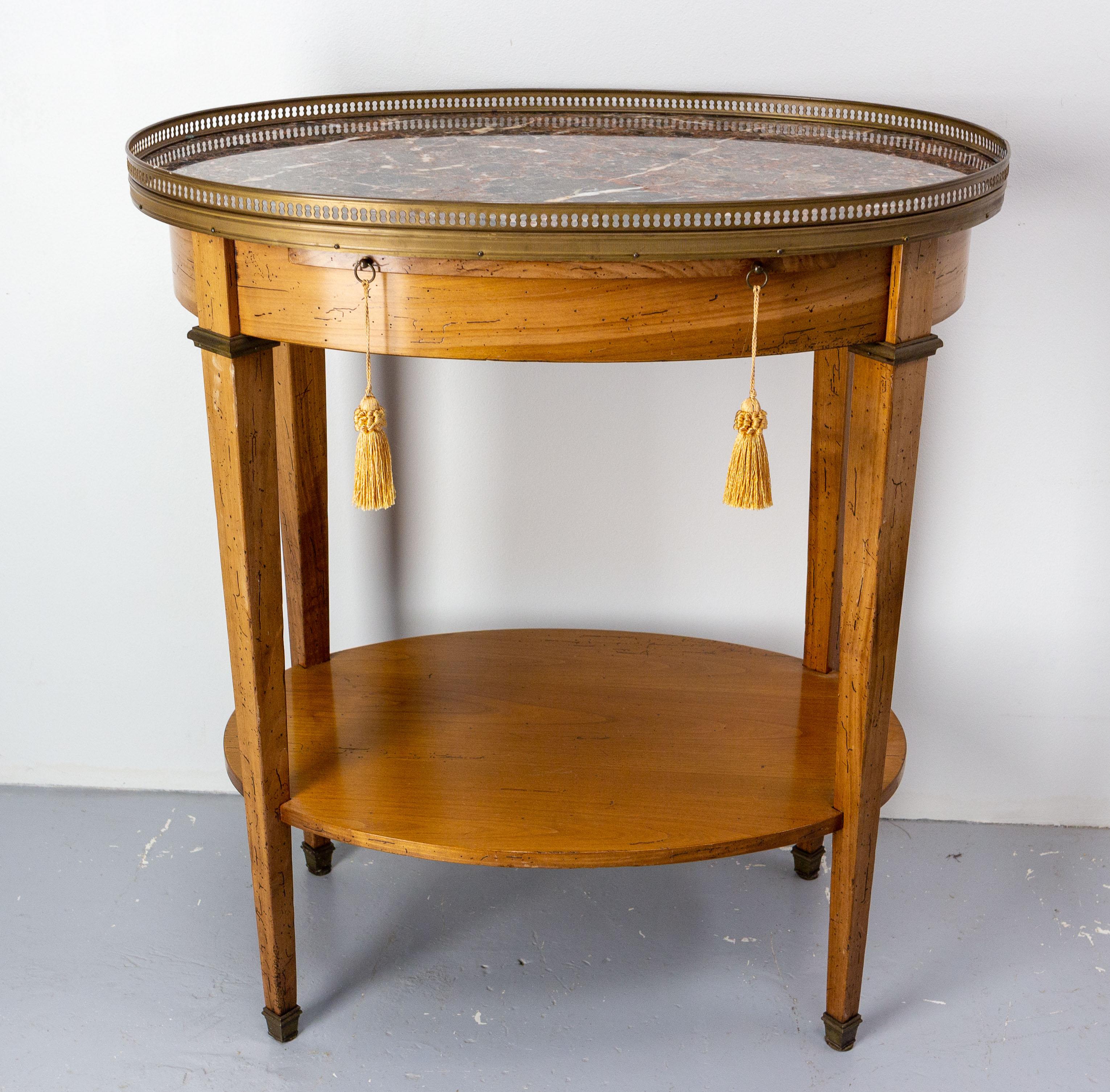 Side table or desserte table in cherrywood with marble top and brass ornements. 
This oval little table in the Louis XVI style was made circa 1980 with the desire to imitate at best an ancient object (for example, wormholes were made by the