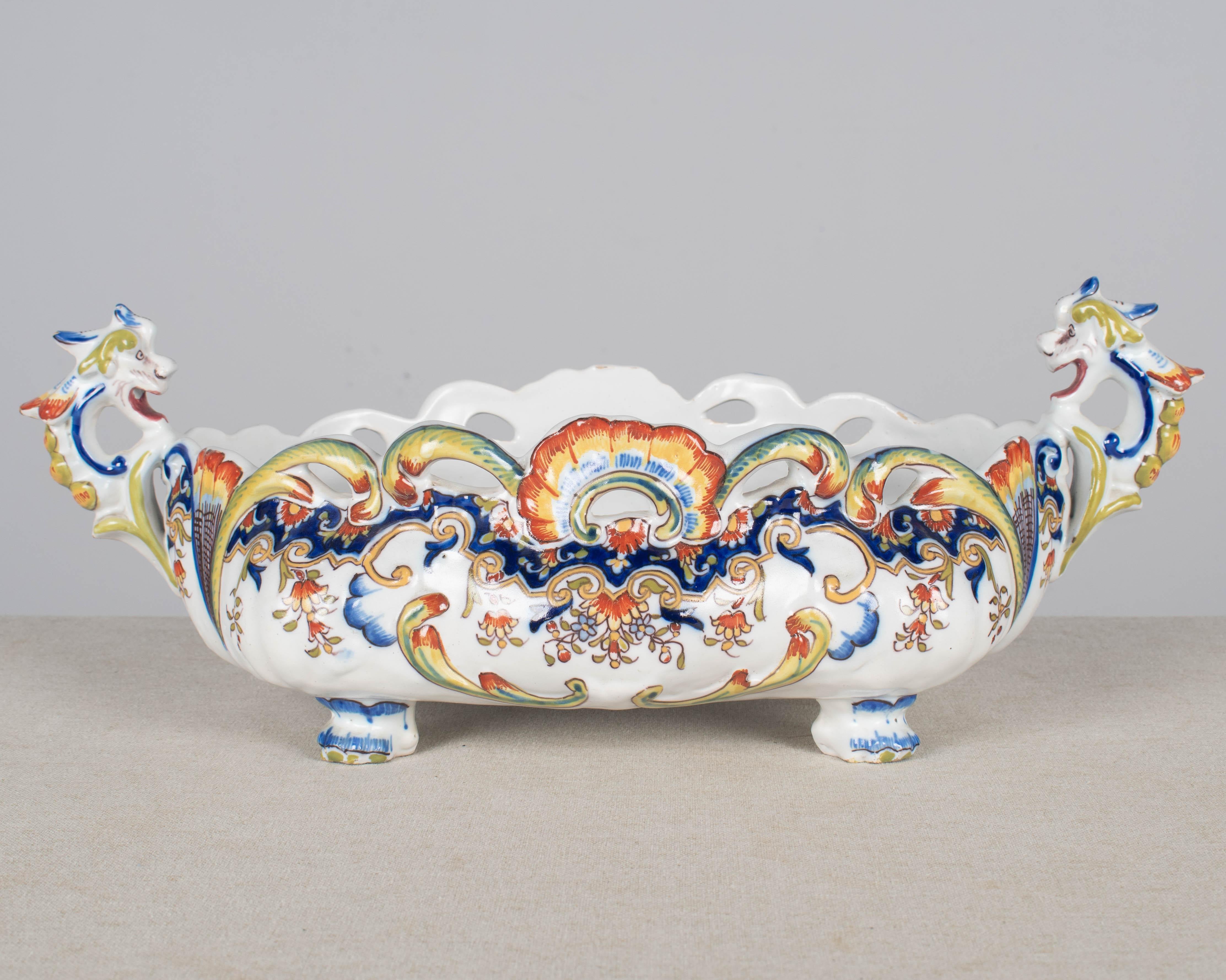 Una jardinière, o cache pot, in maiolica francese di Desvres del XIX secolo. Dipinto a mano con un tipico disegno floreale con bellissimi colori vivaci di blu, verde, giallo e rosso su fondo bianco. Una bella ciotola da centrotavola con piede con
