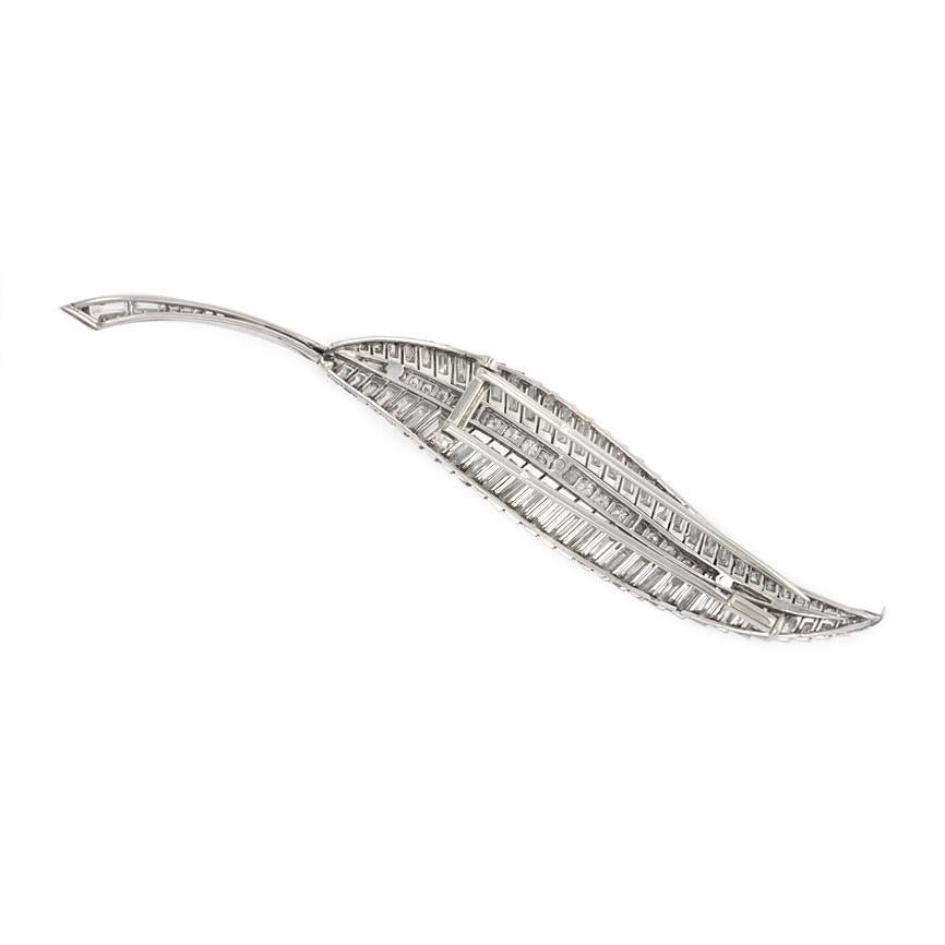 A Retro round and baguette diamond brooch in the form of a leaf, in platinum.  Atw 8.00 round and baguette cut diamonds.  France

Dimensions: Approximately 4 inches long