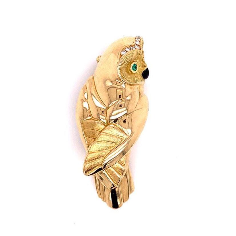 A piece made in France with the quality associated with French jewelers. This 18K yellow gold owl brooch features 0.10 carats of round brilliant cut diamonds, two round emeralds as eyes and a black enameled nose. A cute and light weight piece that