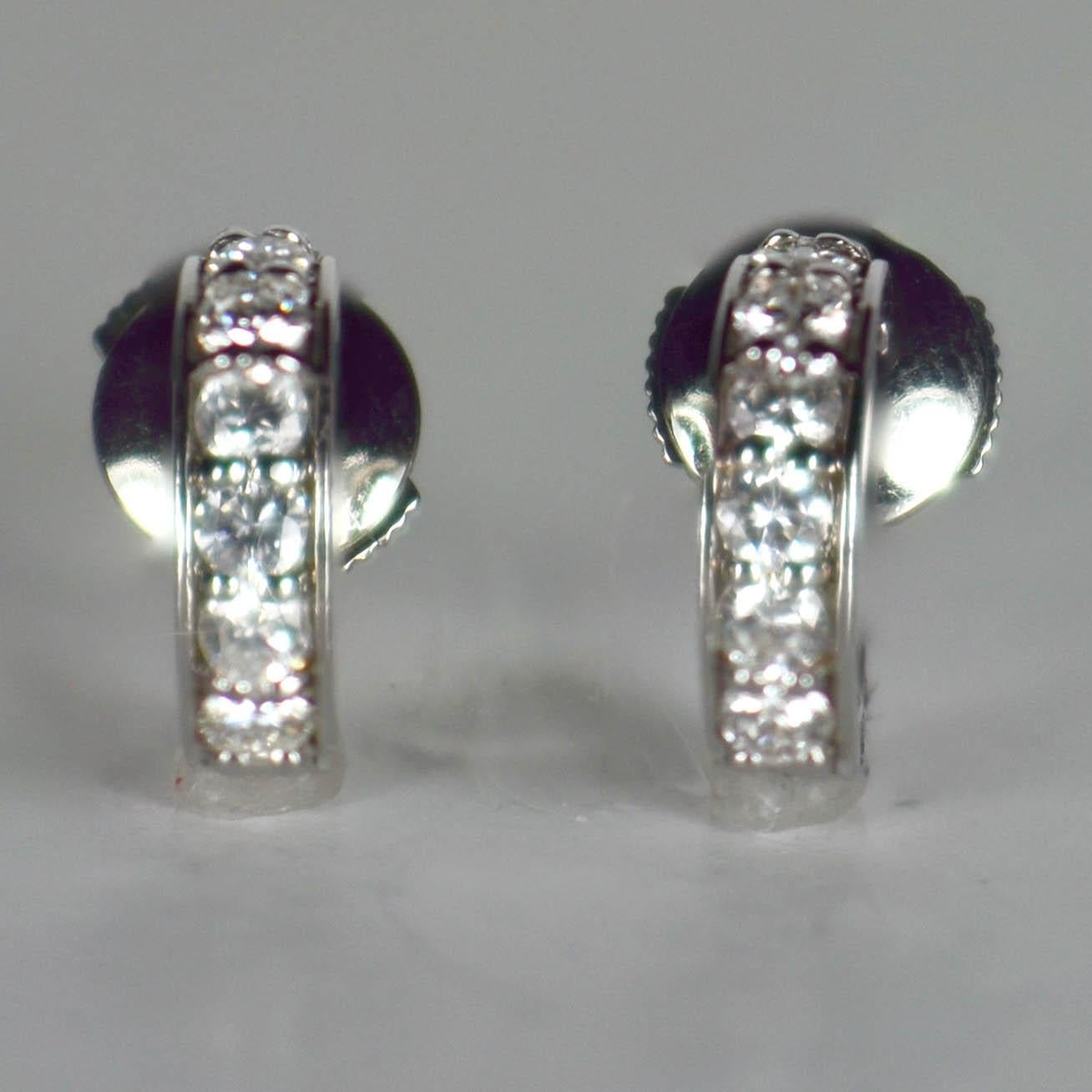 A pair of French huggie style hoop earrings in 18 karat white gold set with a total of 14 round brilliant cut white diamonds with a total approximate weight of 1.12 carats.
Marked with the eagles head for 18 karat gold and an unidentifiable makers