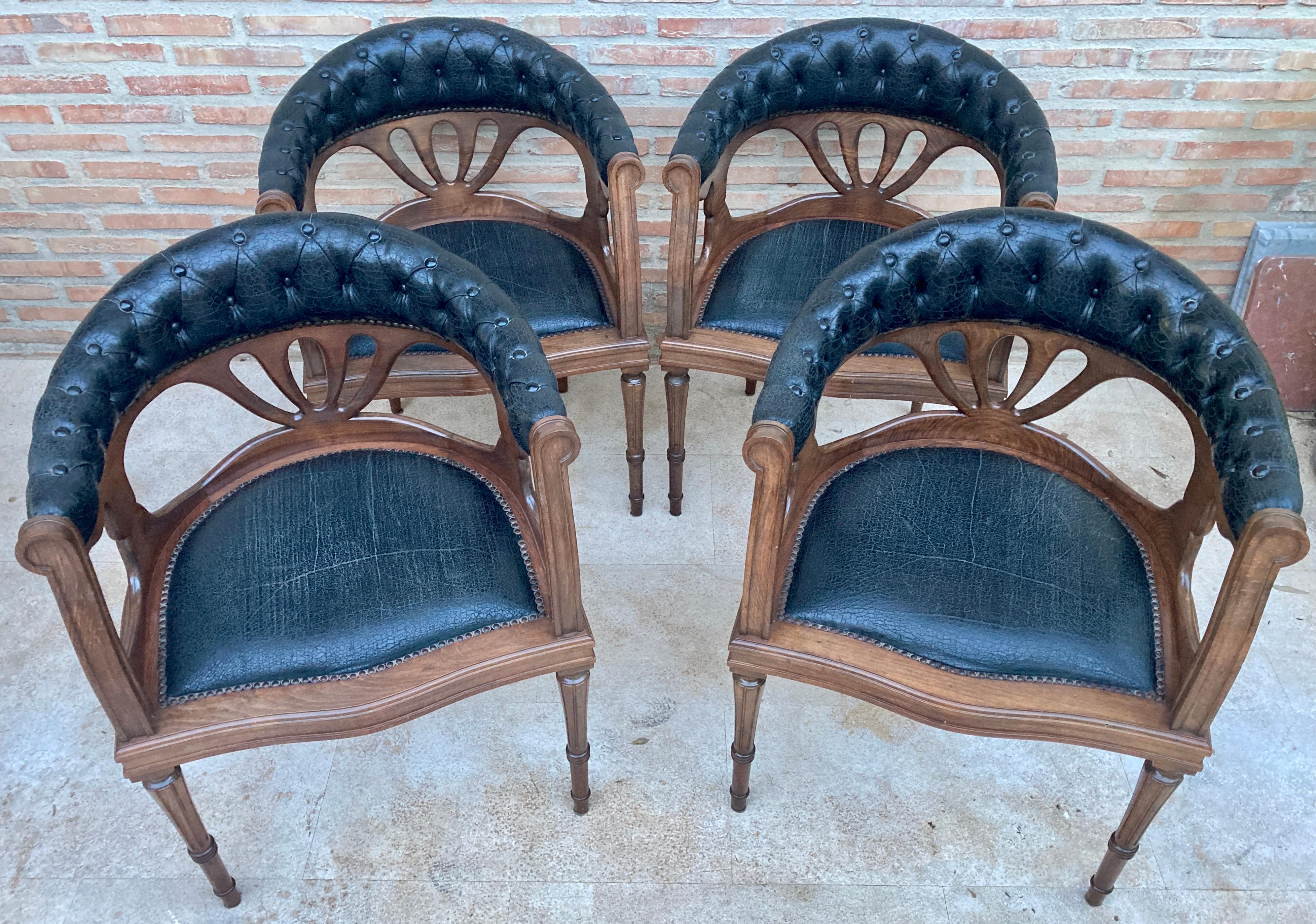 Ensemble de 4 fauteuils en bois de noyer et assise en cuir vintage. Vers les années 1950. 
La caractéristique des chaises est qu'elles sont livrées avec leur revêtement en cuir noir d'origine, légèrement usé par l'usage, mais bien conservé.