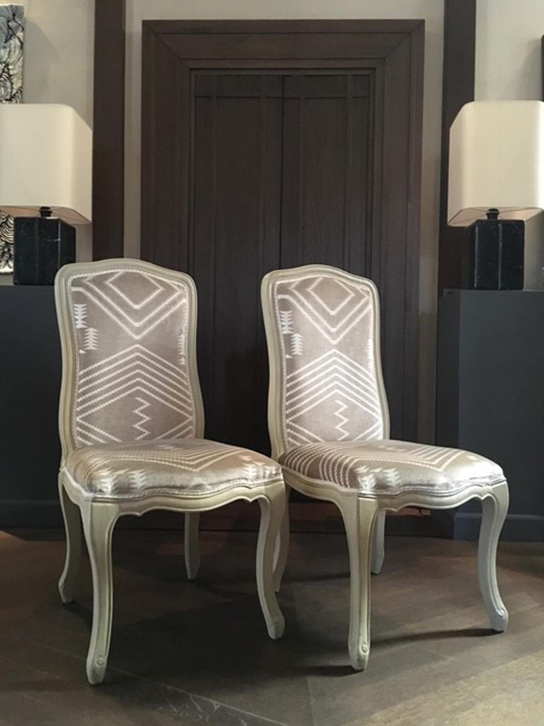 Questa coppia di eleganti sedie francesi,  erano rivestiti di velluto. Il tessuto è realizzato da Andrew Martin a Londra ed è un velluto di cotone con disegni geometrici che sembrano un arredamento primitivo.
La struttura è in legno e sono laccate