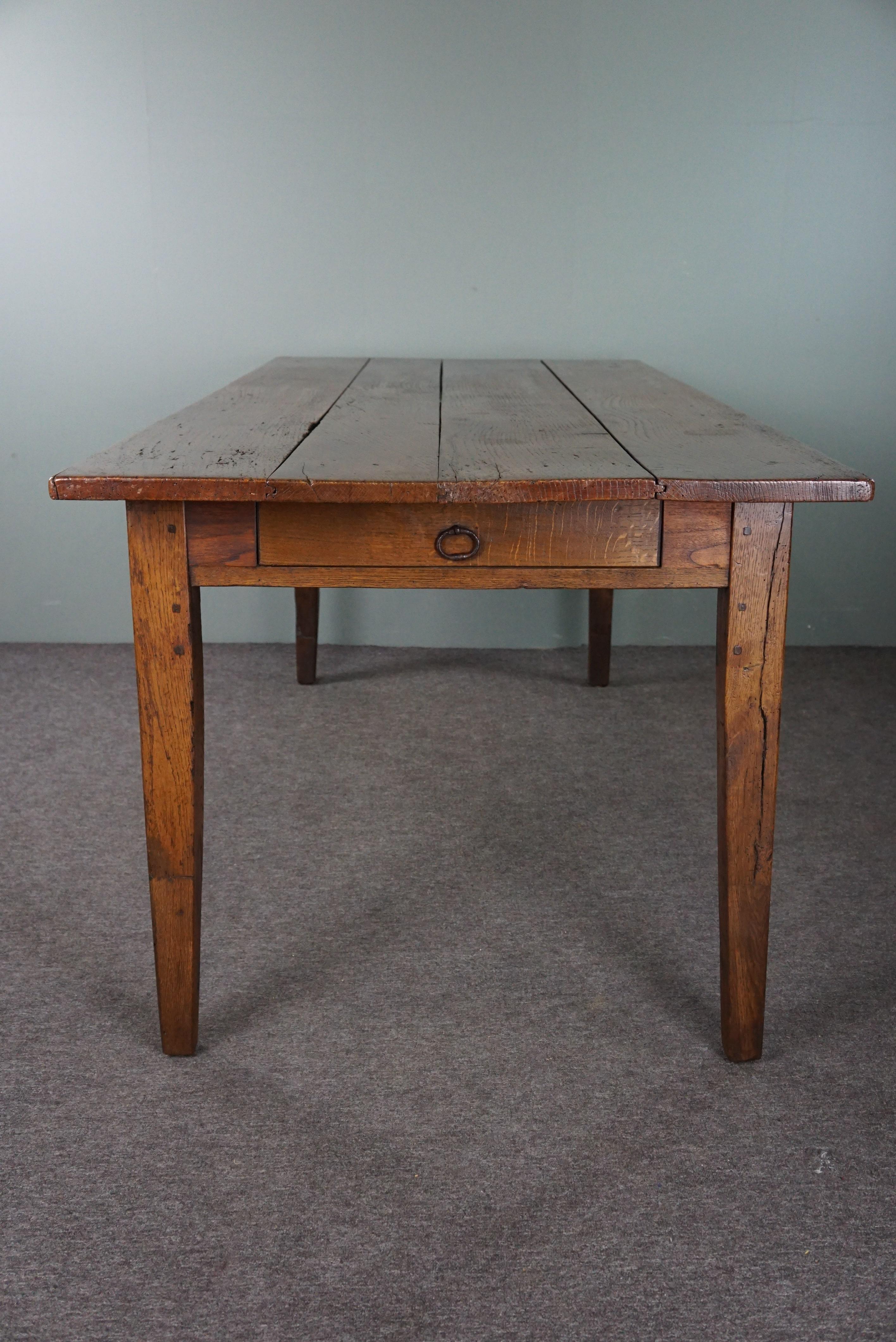 Early 19th Century French dining table dating back to the early 19th century with warm colors For Sale