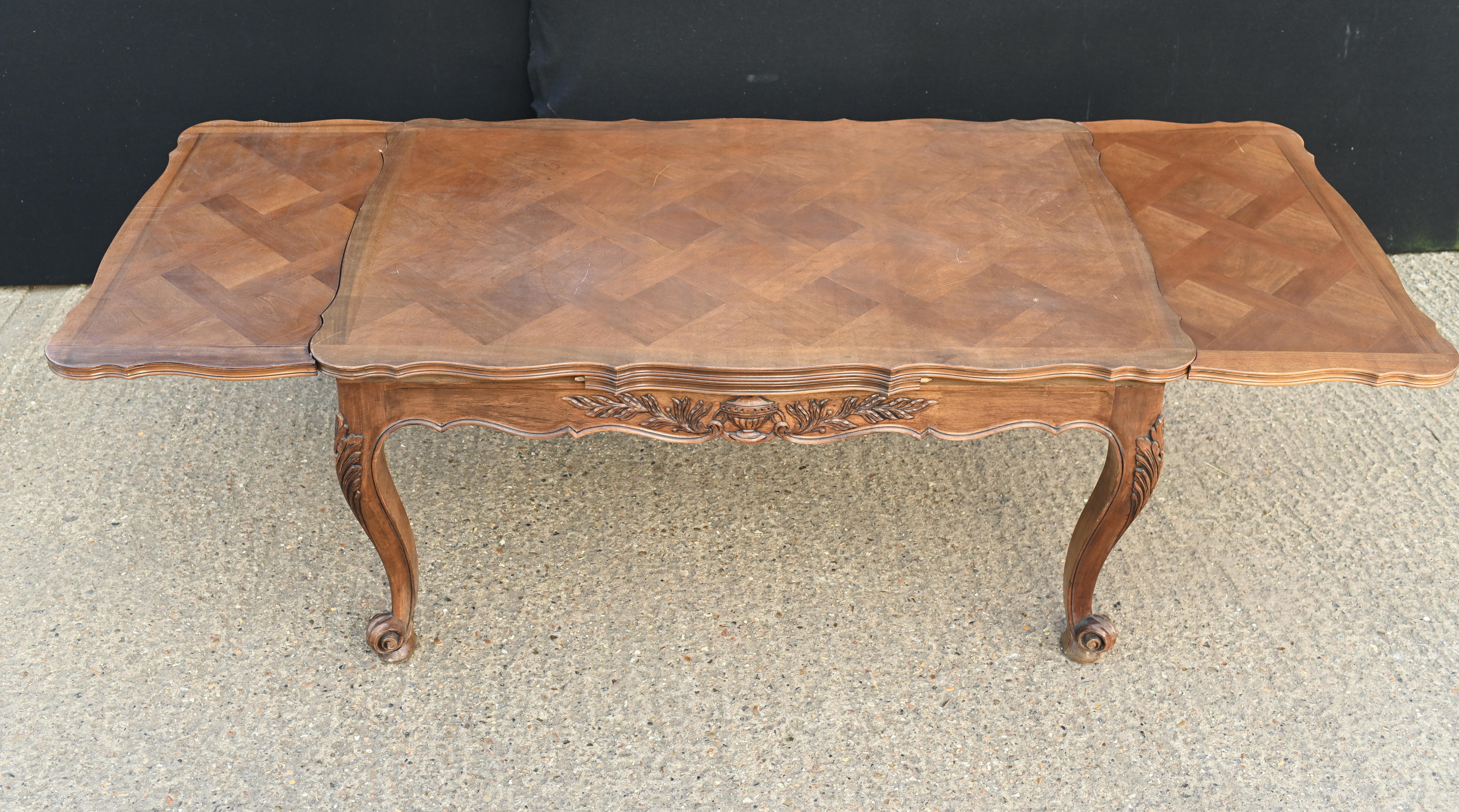 Elegant French provincal extending dining table
Hand carved details to the leg and apron
Also features intricate parquetry designs on the top
Opens out via pullout sections at either end
circa 1920
Bought from a dealer on Marche Biron at Paris