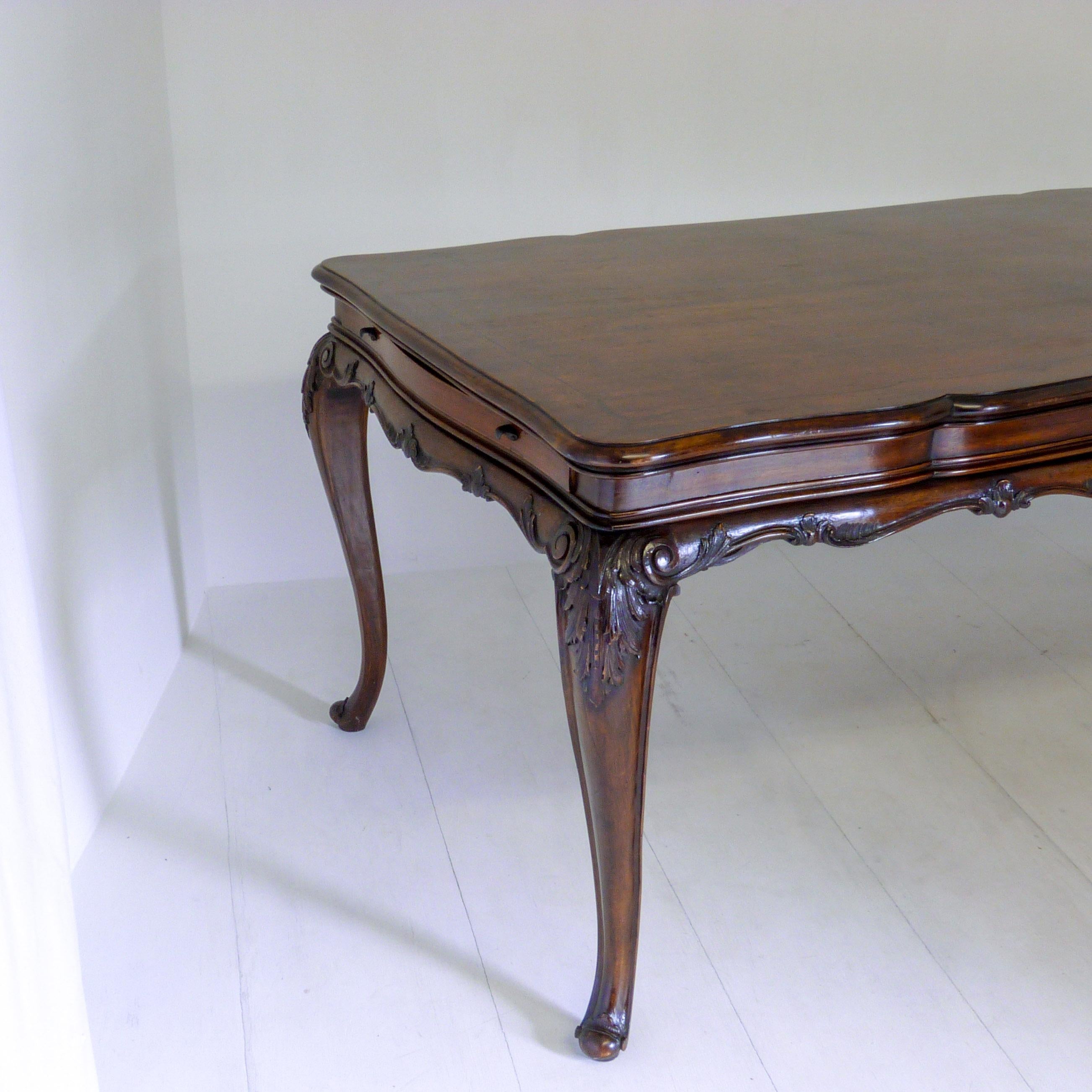 This is a old fruitwood reproduction of a 18th century French dining table, probably made in the 1950s. This piece could equally be used as a centre table, desk or shop fitting. Very elegant cabriole legs with carved acanthus to the shoulders and a