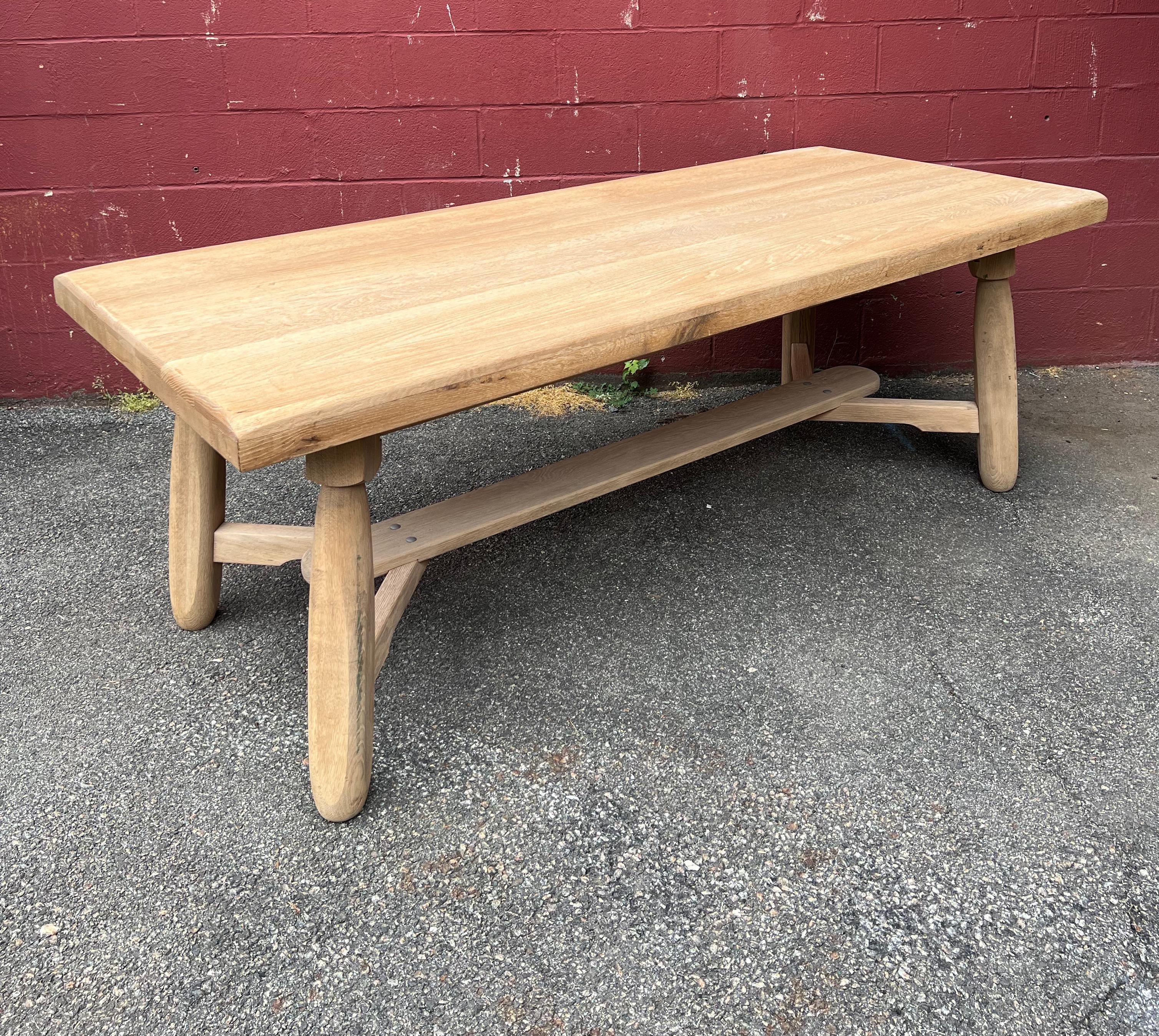 An unusual French dining or library table with a solid thick top mounted on an interesting base of elongated legs. The table has recently been stripped and bleached and it can be used as is or it can be waxed to give it more luster. Additionally the