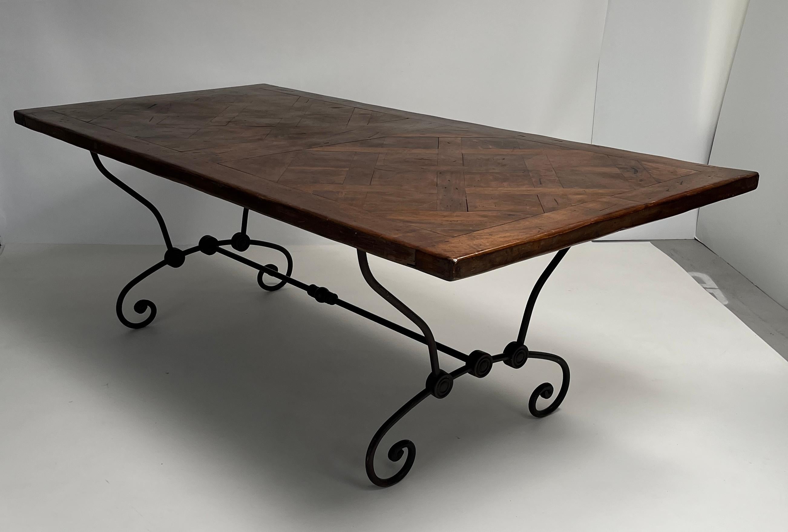 Crafted from reclaimed hardwood flooring and finished in rich walnut tones, this striking French dining table blends rustic elegance with industrial artistry. The expansive 83-inch top showcases a geometric parquet pattern, offering warmth and