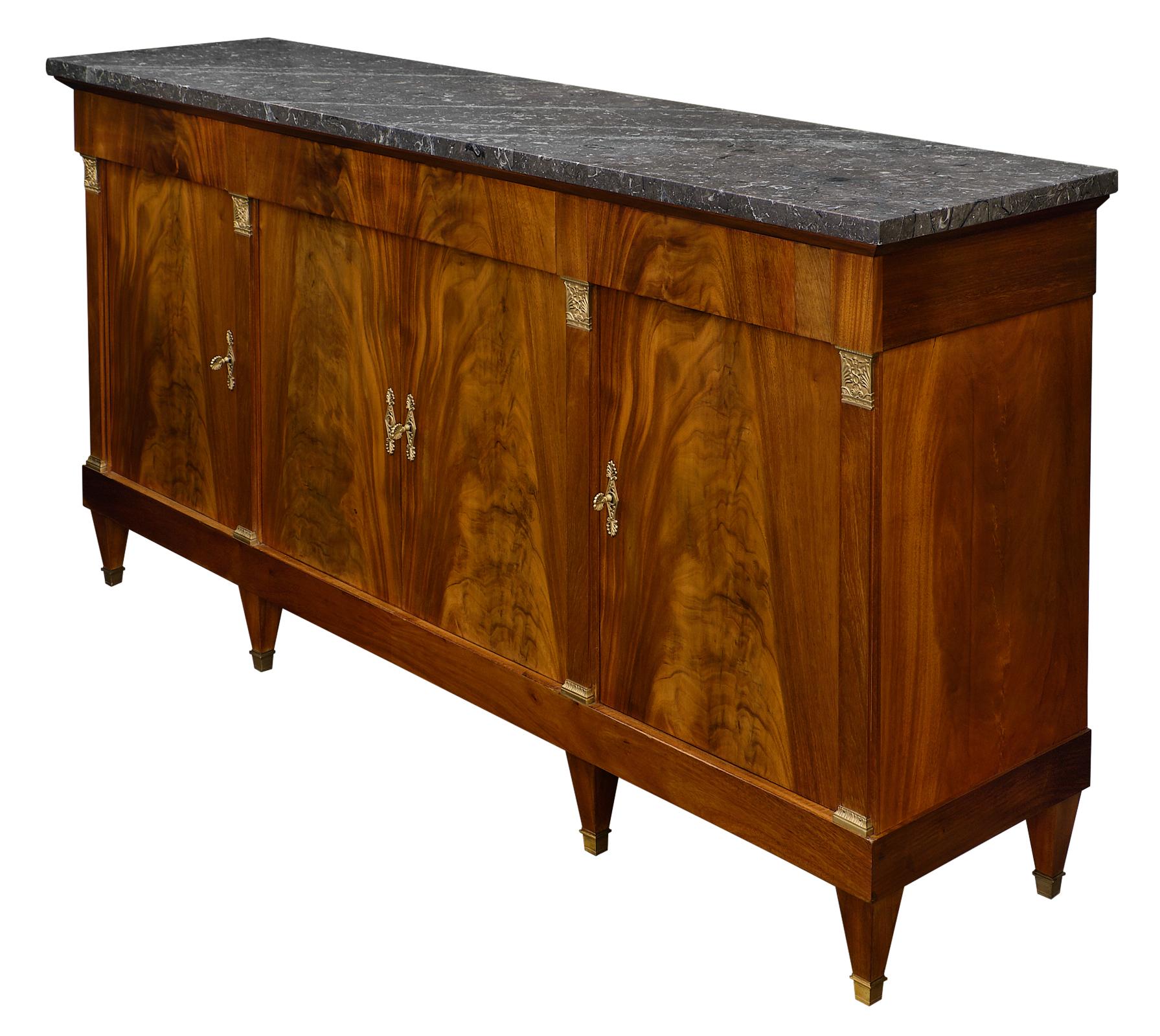 Antique flamed mahogany French Directoire buffet with gray marble top. This piece is made of Cuban flamed mahogany enhanced with acanthus leaf decor in bronze. The gray turquin marble top is original and in excellent antique condition. Three