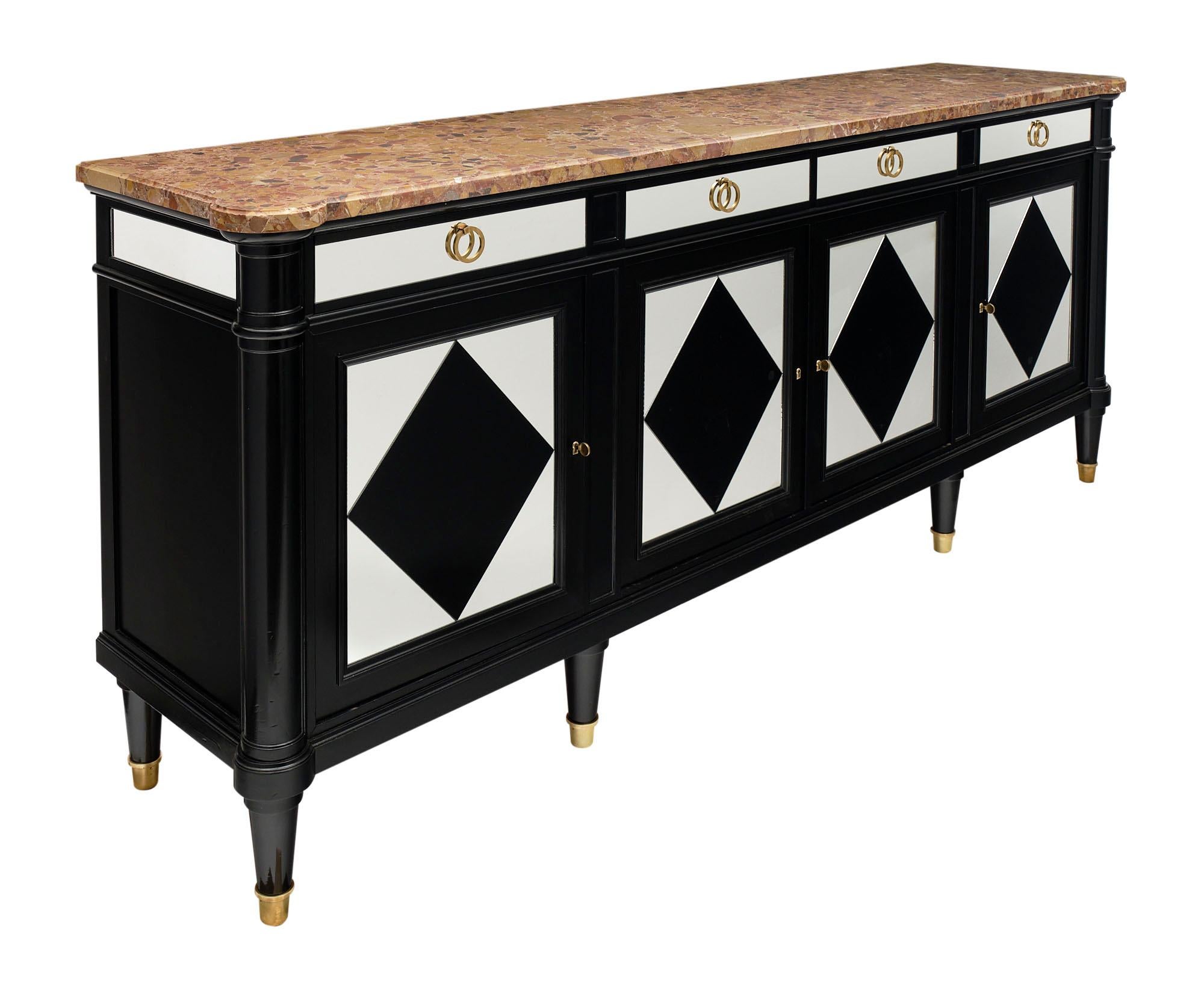 Buffet / enfilade made of cherry wood that has been ebonized and partially veneered with black glass and mirror in a diamond pattern. There are four dovetailed drawers above four doors which open up to ample storage. The gilt bronze hardware and