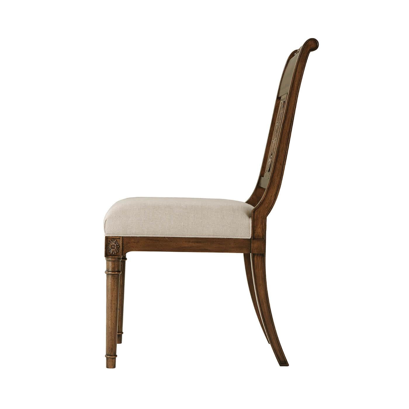 French Directoire style dining chair, a hand carved distressed beech and oak dining chair with turned top rail, an upholstered cushion seat raised on turned and tapered legs with flowerhead carved capitals.

Dimensions: 21