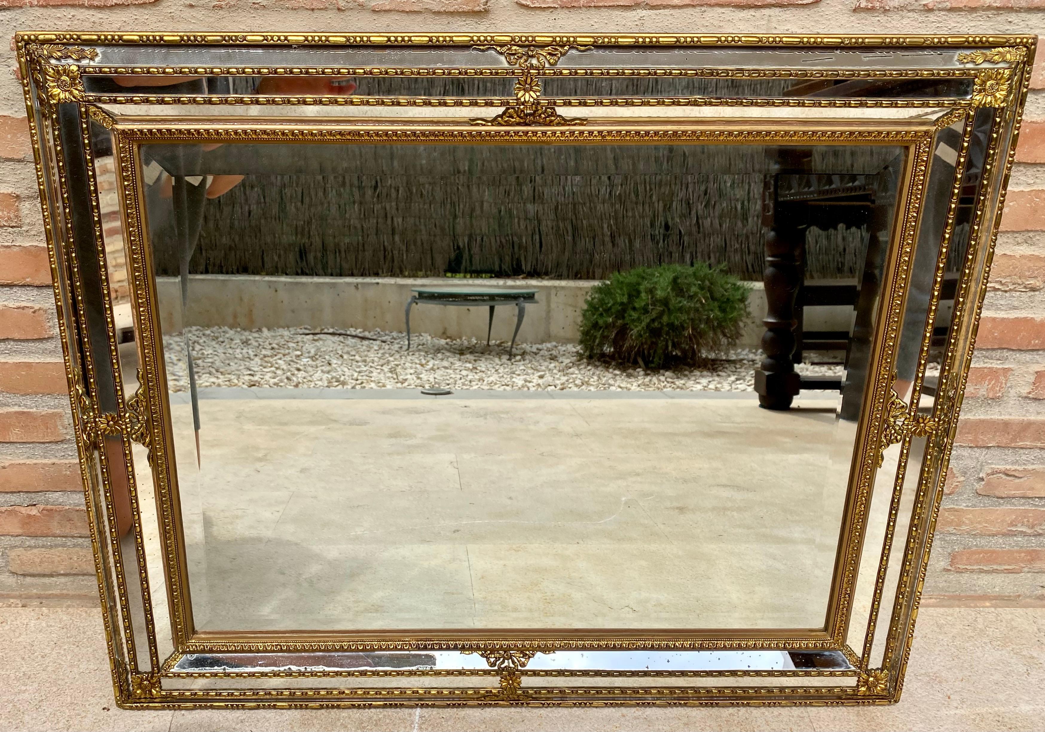Il s'agit d'un magnifique miroir en feuilles d'or. Le miroir est en bois sculpté et non en plâtre. L'or est très bien fait et a une belle patine. Miroir vénitien de style classique datant du milieu du 20e siècle.