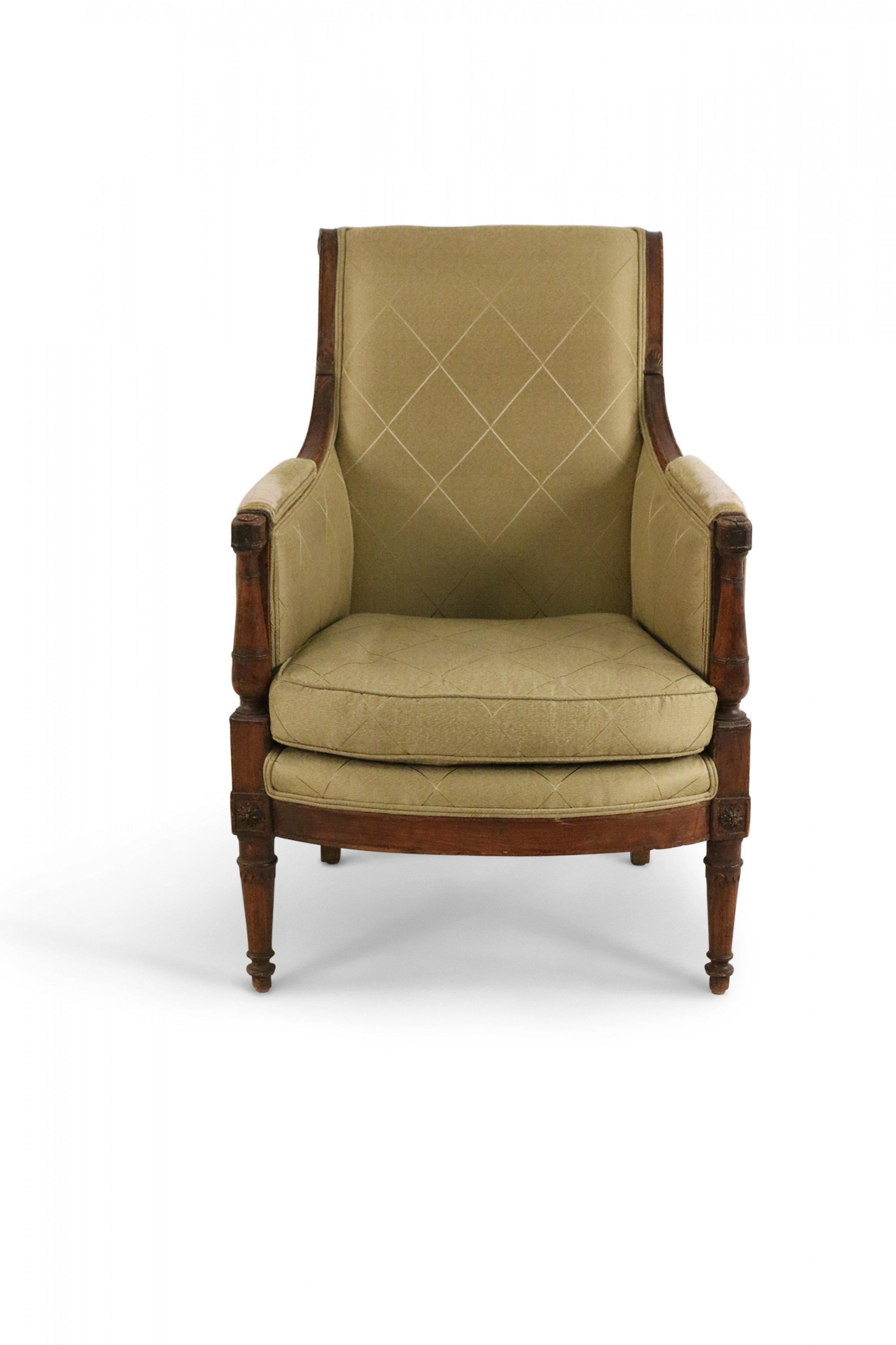 French Directoire bergere armchair with pale green diamond patterned upholstery and walnut frame with curved backrest and padded armrests on baluster-shaped supports with a seat raised on baluster-shaped and sabre legs.(Companion piece: 062745,