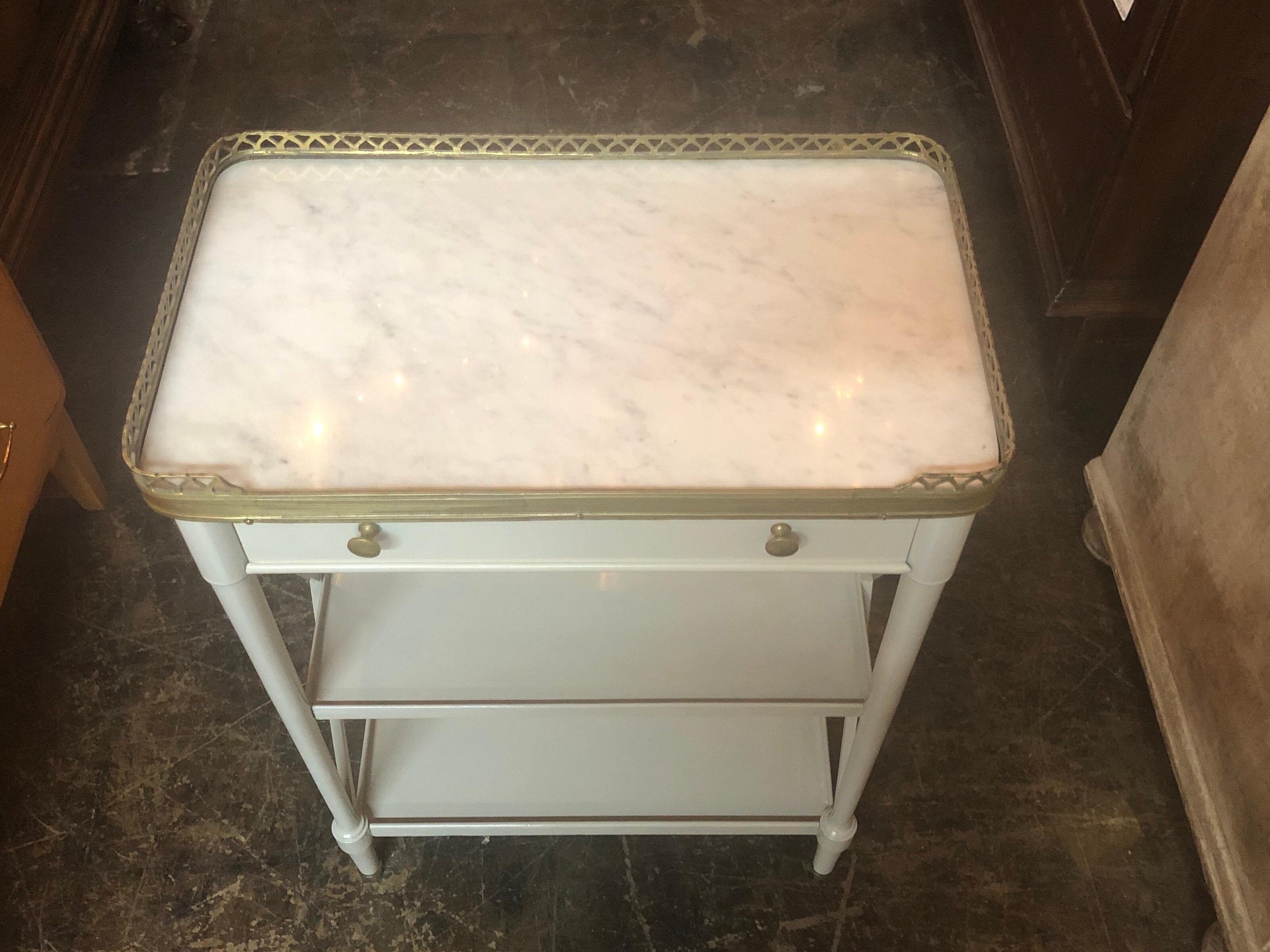 Beautiful French Directoire' style grey lacquered side table. The table has a brass gallery and a lovely Carrara marble top. A very pretty piece!