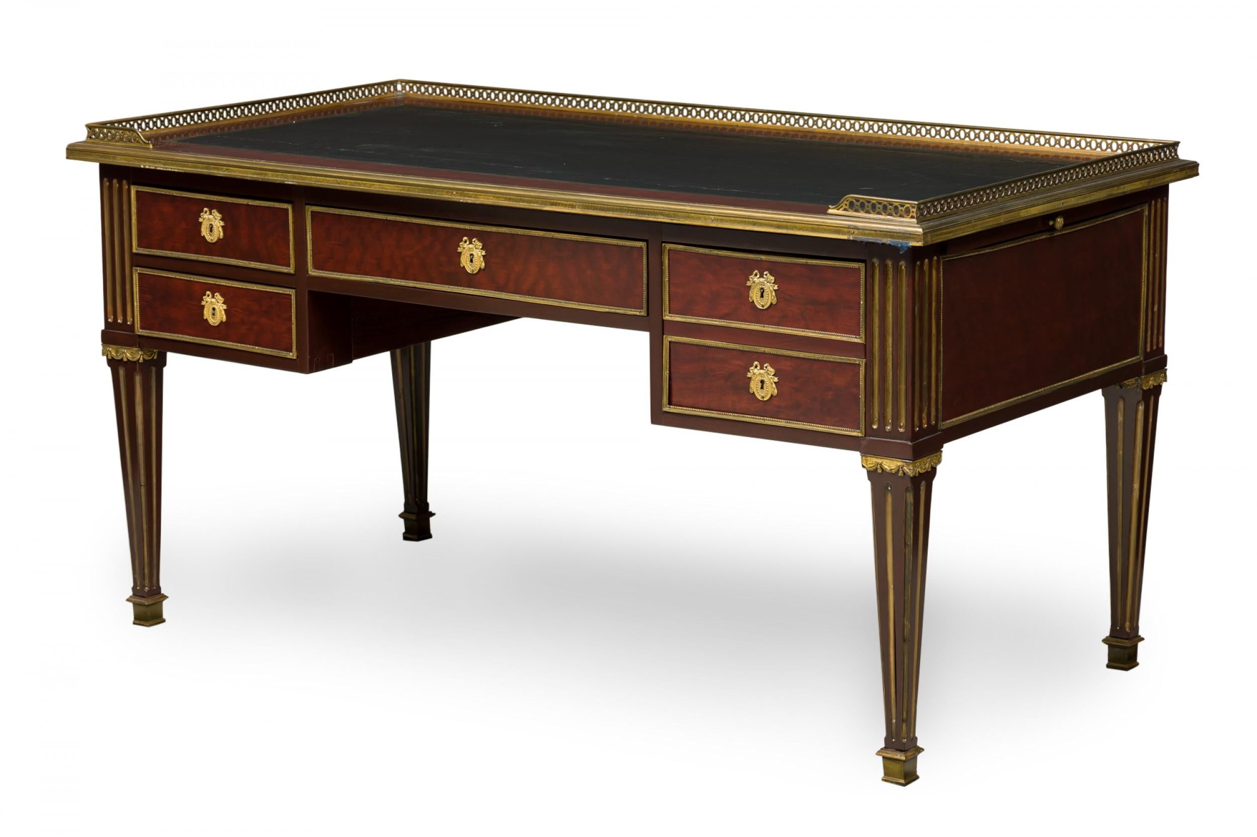 French Directoire (Late 18th Century) mahogany desk with a black leather top surrounded by a shallow reticulated brass gallery, having two drawers on either side of a central drawer, and an additional black leather topped writing surface that