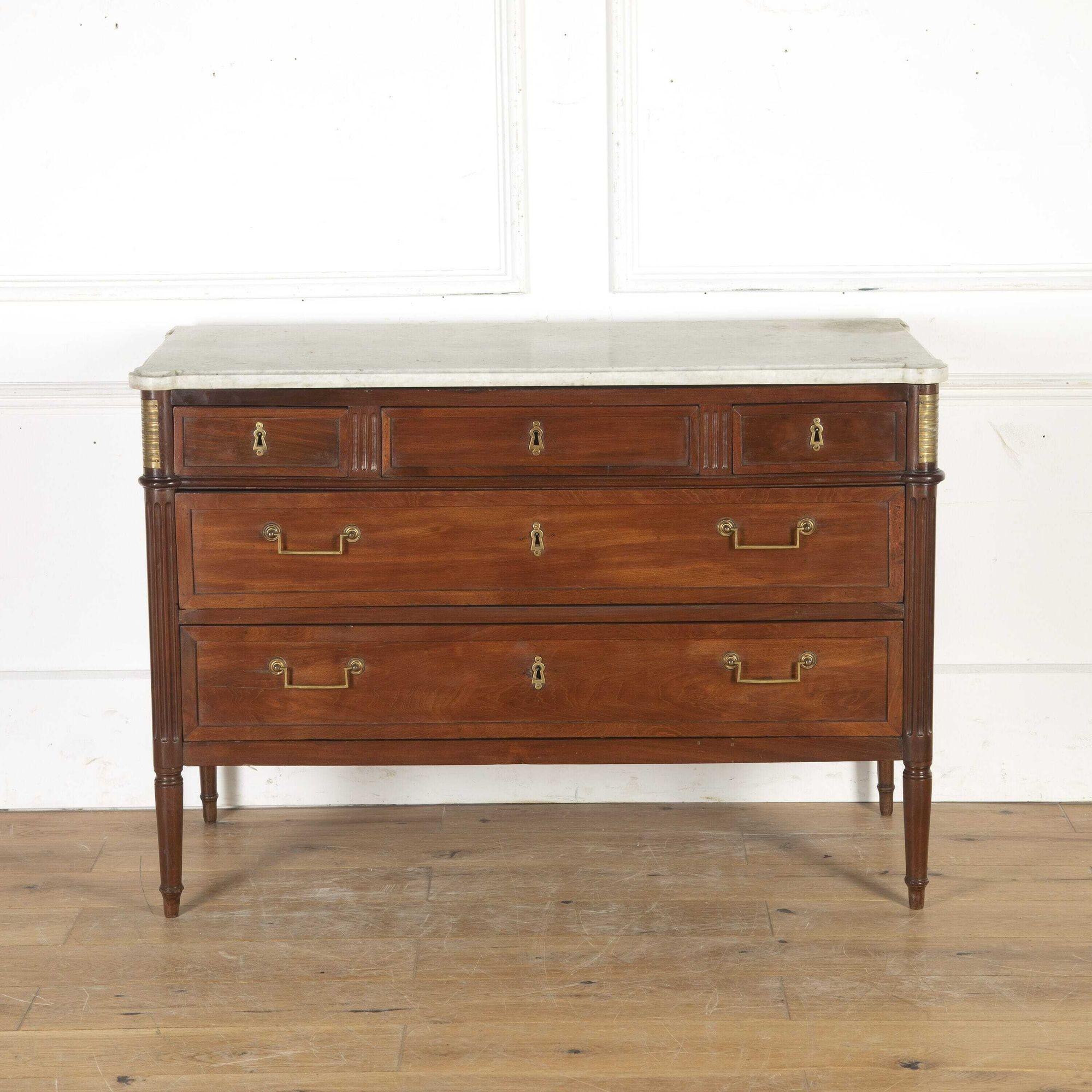 Very smart French Directoire mahogany commode, circa 1800. 
This commode retains its original white marble top with rounded corners. The top sits over three short drawers to the frieze which are separated by fluted panels. Two long drawers are