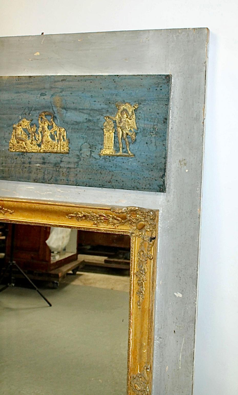 Miroir trumeau en bois peint et doré du Directoire français du XIXe siècle, avec des figures classiques en relief doré. Le miroir est dans un cadre doré orné sur un panneau arrière en bois avec un dessus rectangulaire peint en bleu avec des