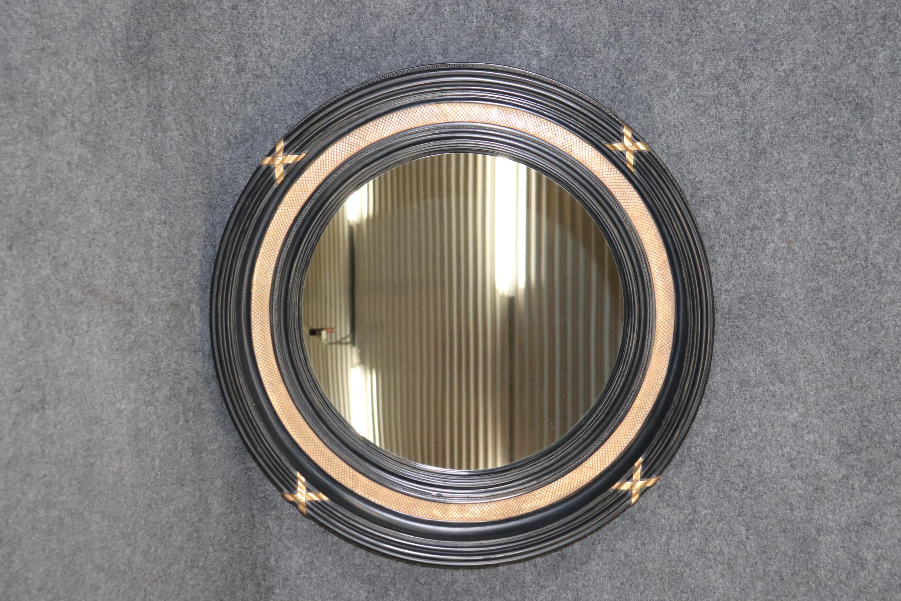 This is a beautiful ebonized and gilded wall mirror in the directoire taste. The mirror measures 33.25 x 33.25 x 4.5 deep.