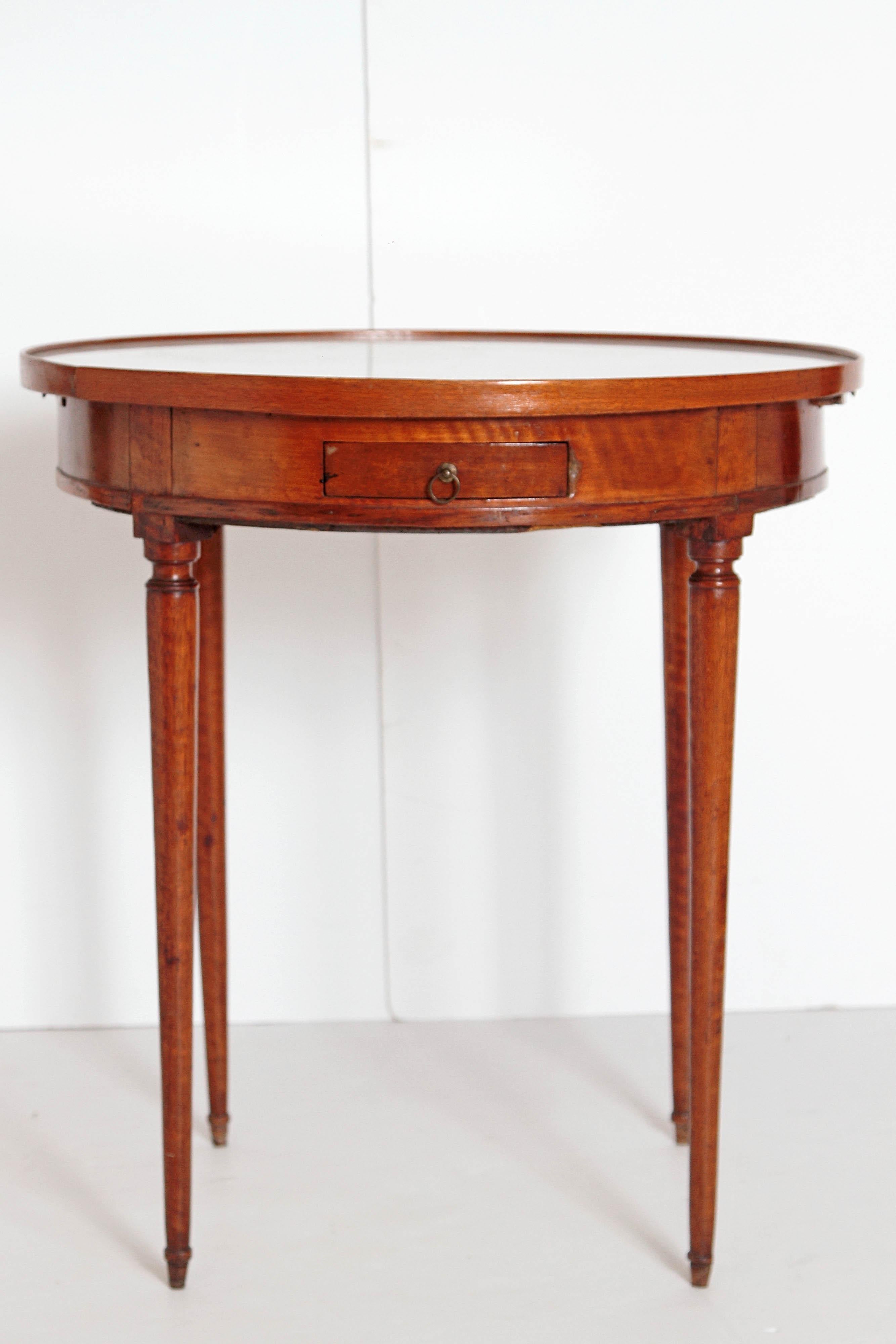 A fine quality French fruit-wood gueridon with white marble top supported on round tapered legs. There are two small drawers and two candle slides, late 19th century, France.