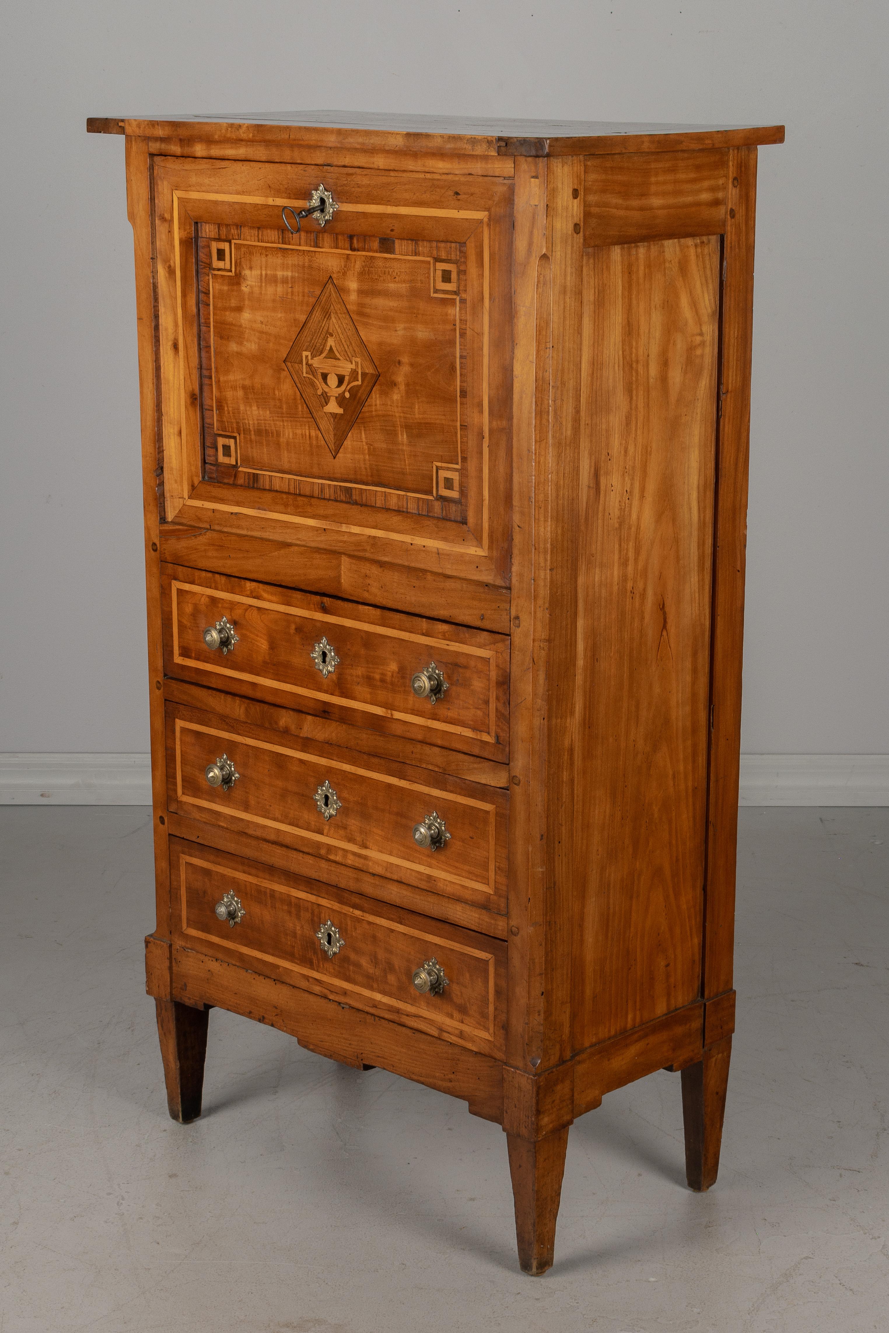 An early 19th century French Directoire style small scale marquetry secretaire à abbattant. A fine child's size desk made of solid cherry wood with inlaid decoration of an urn on the front. Opening to an interior with four small drawers and a hinged