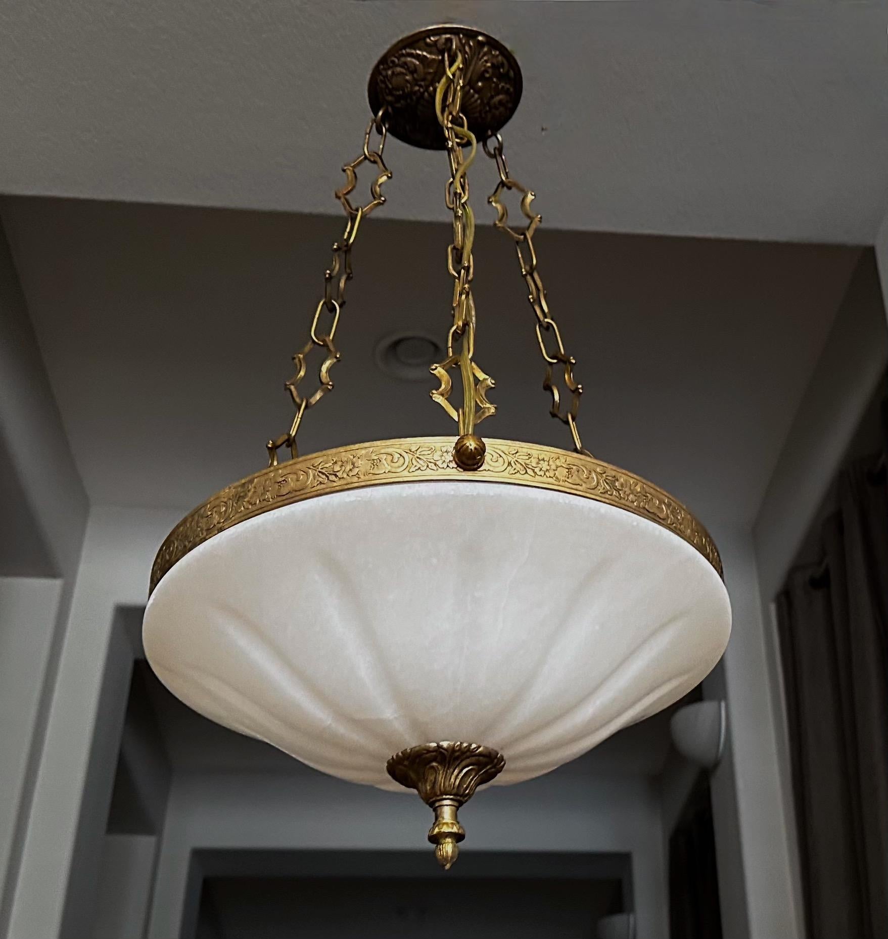 Alabaster pendant light or chandelier with aged patinated brass fittings in the Directoire style. Expertly carved with incised sunburst pattern design. Wired for US, fixture uses three candelabra size bulbs. 

Measures: Alabaster is 16
