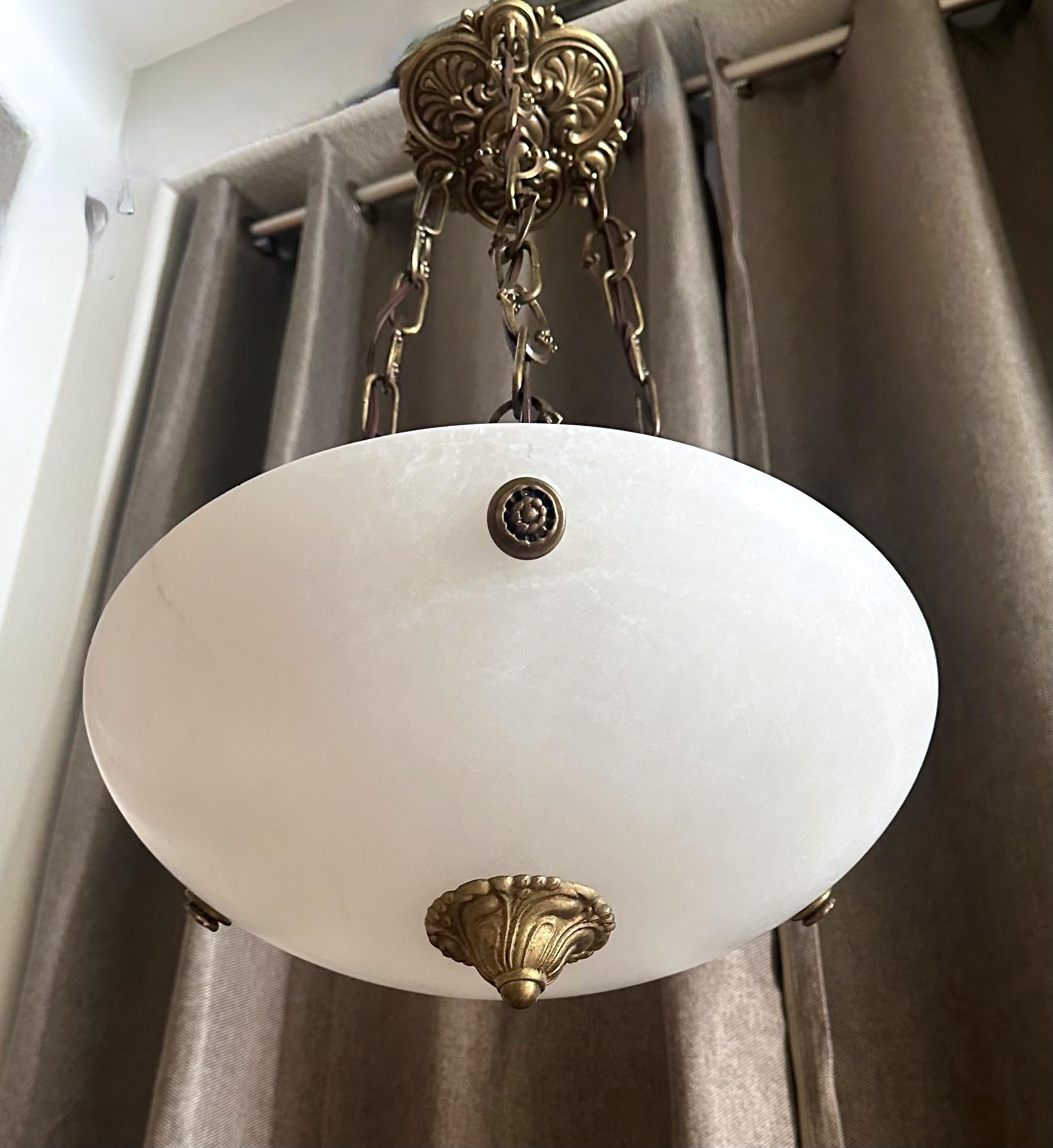 Lampada a sospensione o lampadario in alabastro con finiture in ottone patinato invecchiato in stile Directoire. Cablato a nuovo per gli Stati Uniti, l'apparecchio utilizza tre lampadine a candelabro. La scala ridotta di questo apparecchio è