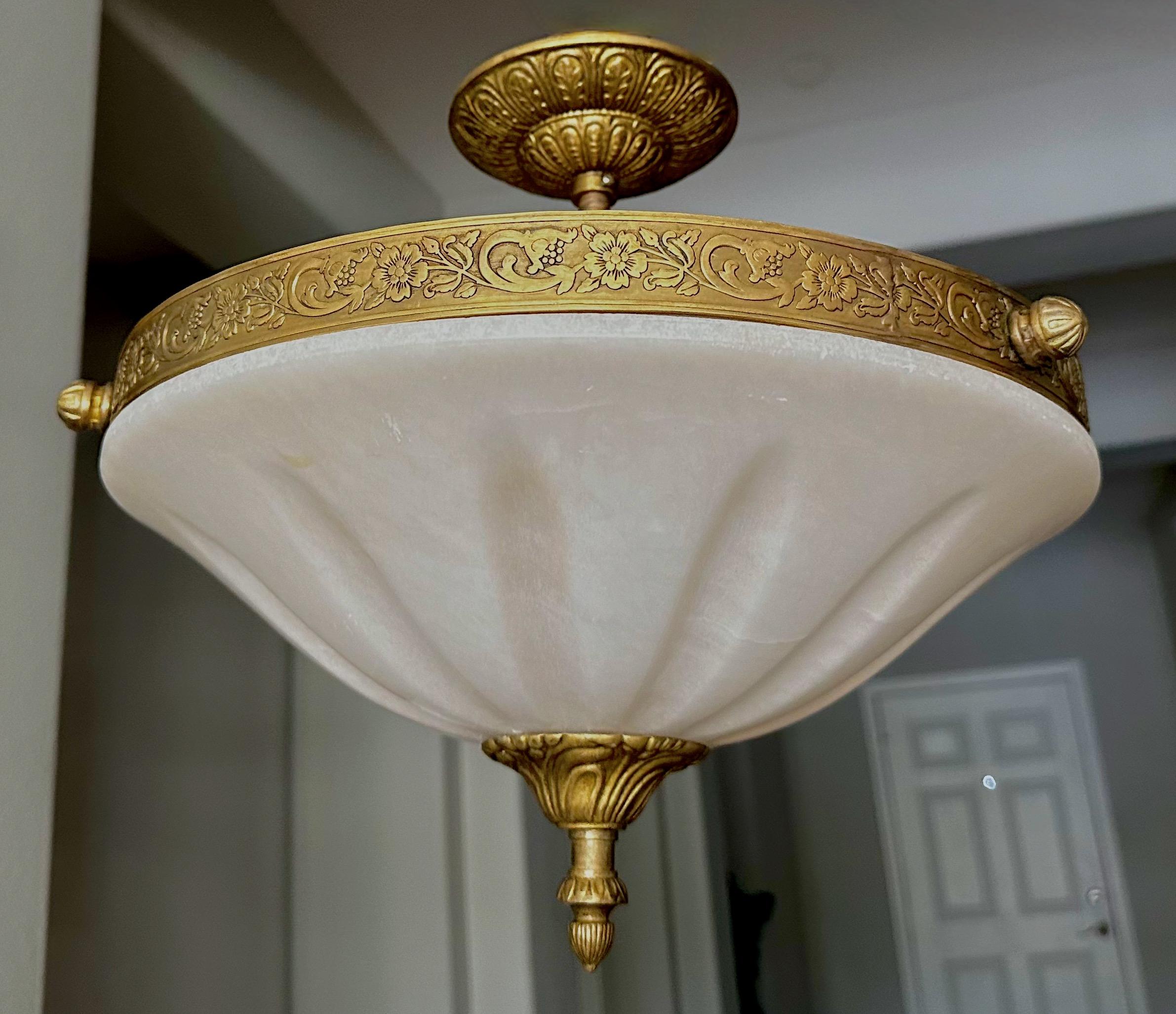 Alabaster flush mount ceiling light with aged patinated brass fittings in the Directoire style. Wired for US, fixture uses two candelabra size bulbs. 

