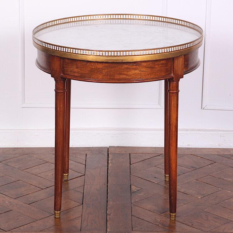 An early 20th century French Directoire style ‘bouillotte’ table having a Carrera marble top with pierced brass gallery, the apron fitted with a single drawer, the whole raised on turned tapering legs with brass feet, circa 1920.

 