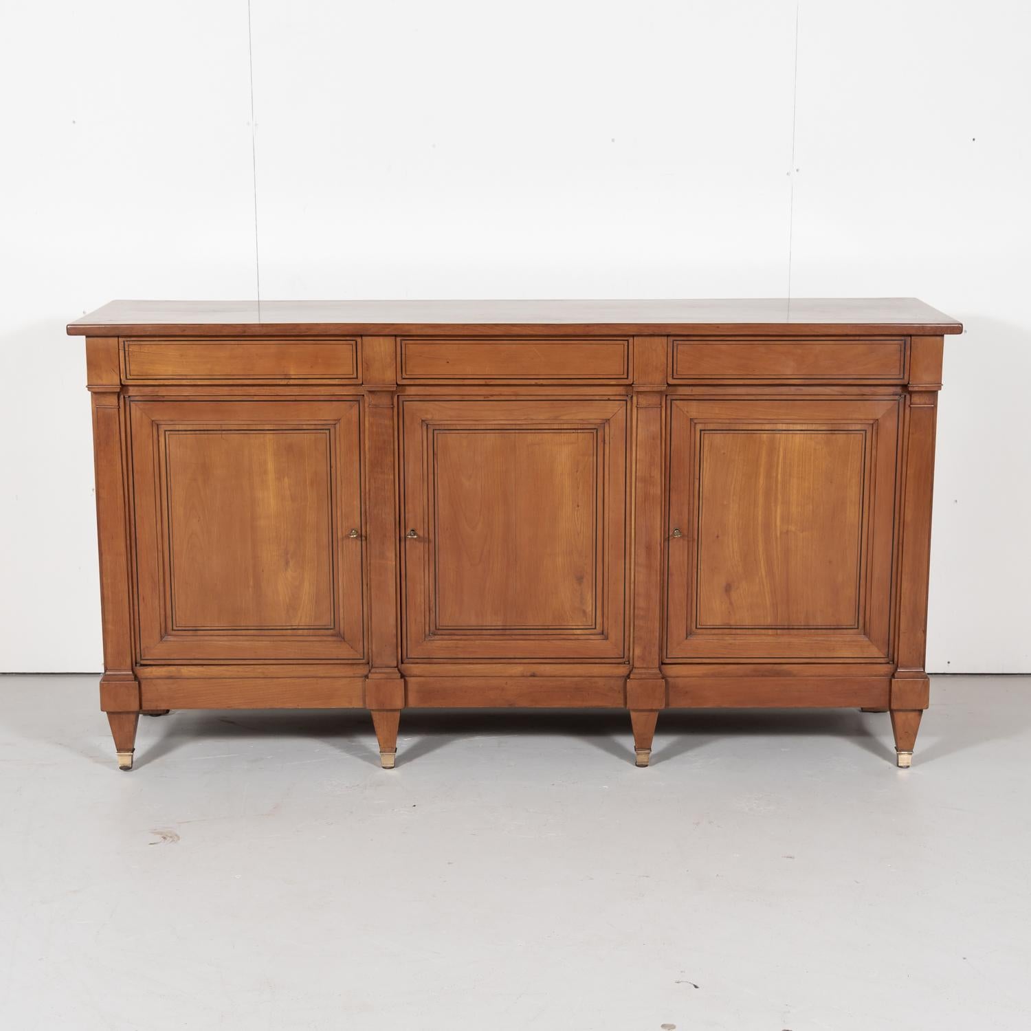 Handsome antique French Directoire style enfilade handcrafted in the Occitane region of cherrywood with ebony inlay, circa 1910s. Rectangular top above three drawers over three panel doors divided by pilasters. Raised on short tapered legs with