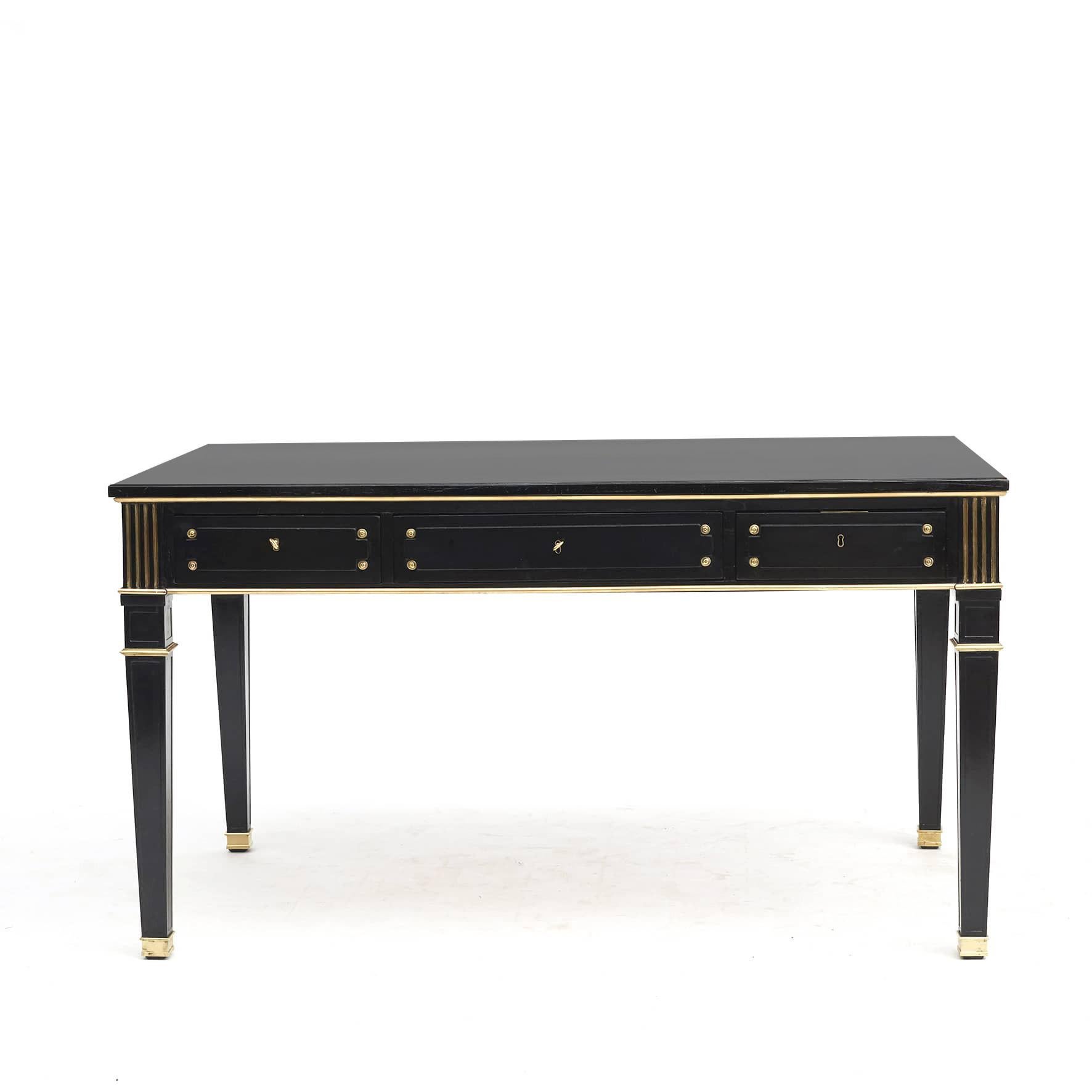 French 1900s 'Directoire Style' or ‘Louis XVI style’ ebonized mahogany desk with gilt bronze trim.
Freestanding with 3 drawers in the front and 3 faux drawers on the back, decorated with bronze rosettes. Fluted bronze decorations on the
