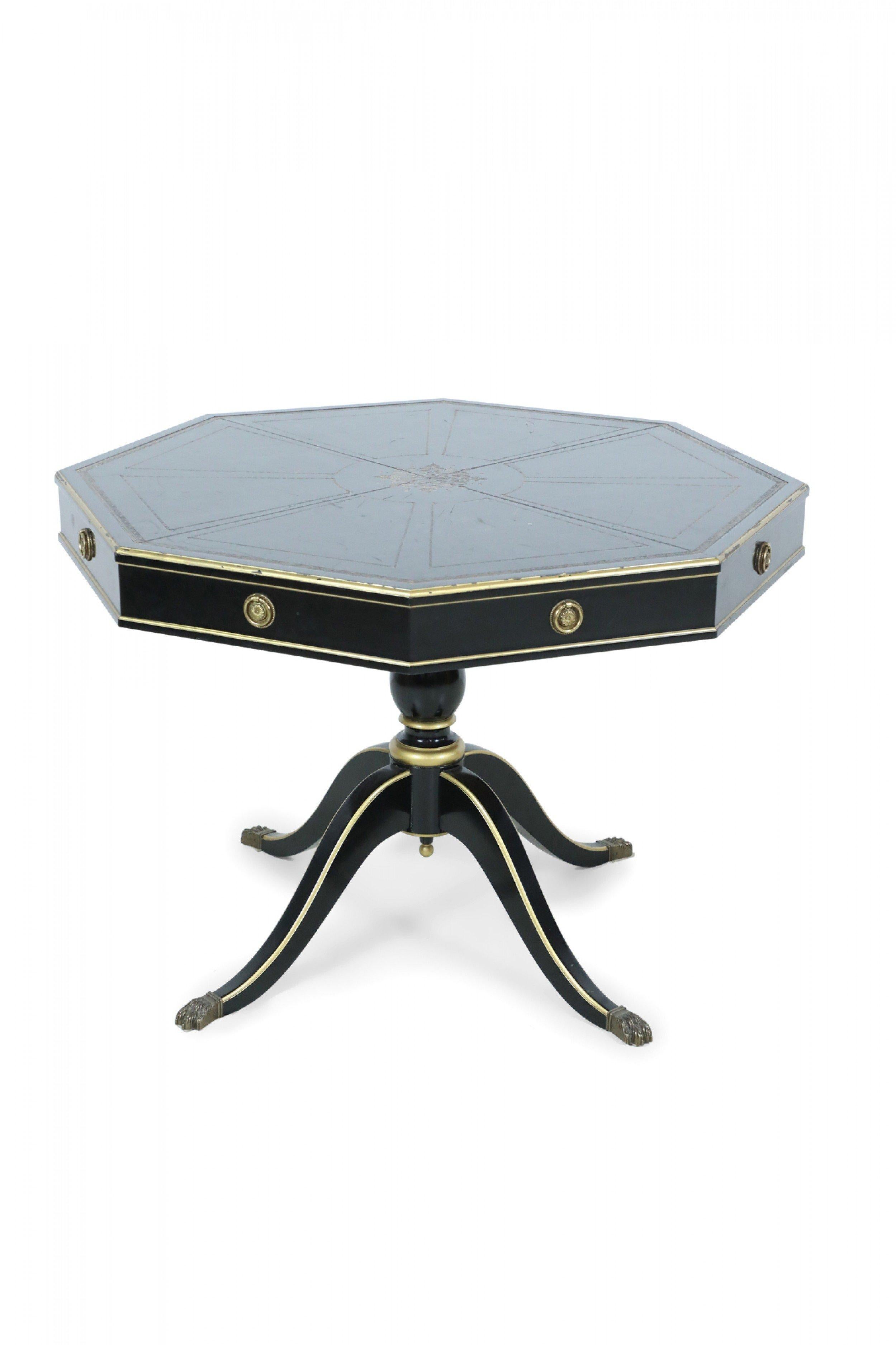 Table centrale hexagonale de style Directoire français avec finition ébonisée, garnitures et détails dorés, plateau en cuir gaufré doré et poignées de tiroir décoratives en bronze, reposant sur une base piédestale dont les pieds se terminent par des