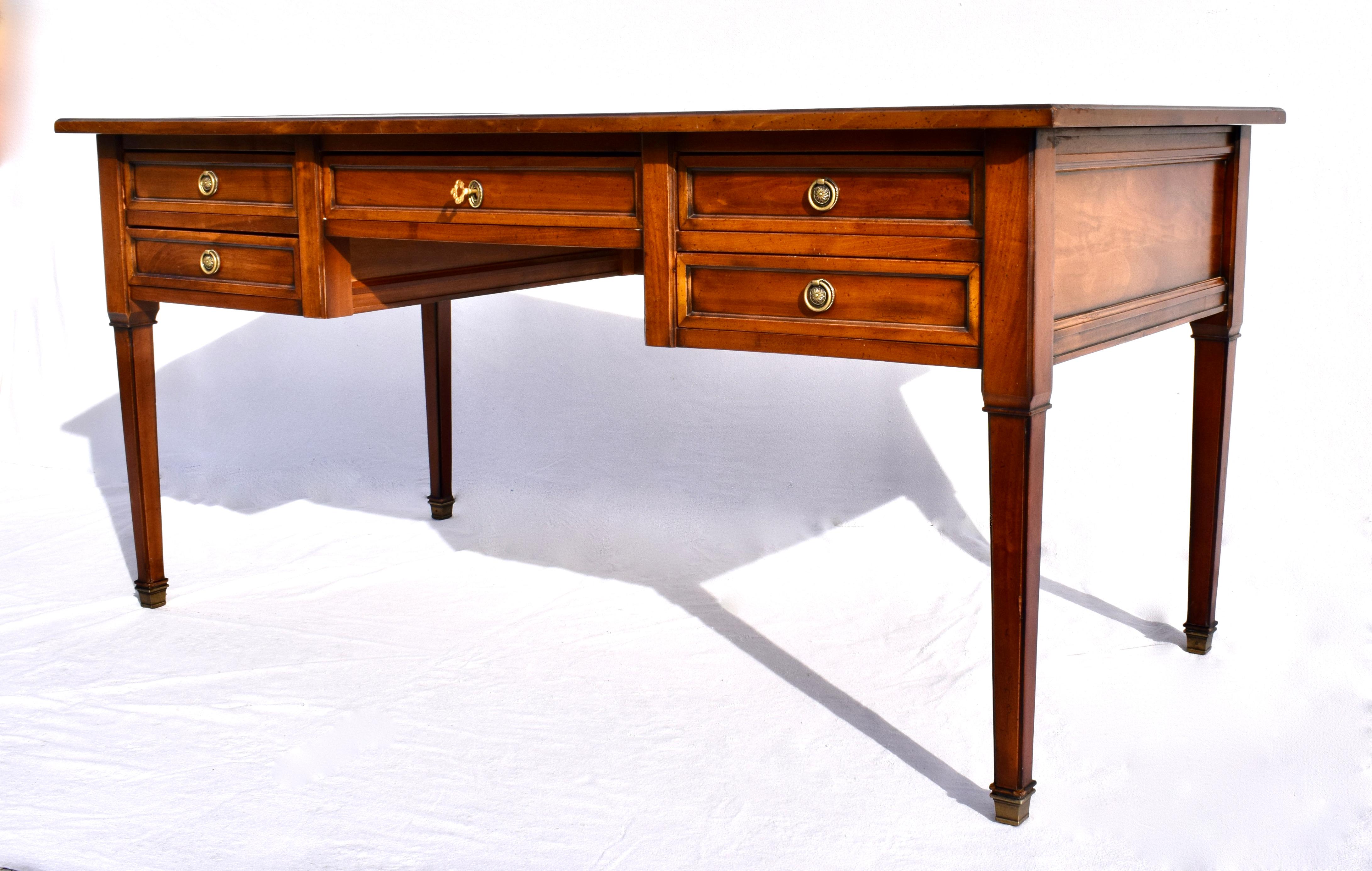 Directoire style desk hand-crafted of solid Mahogany or cherry-wood features five dovetailed drawers with working lock & decorative key. Finished on all sides with striking green tooled leather top of classic lines suitable for open floor plan
