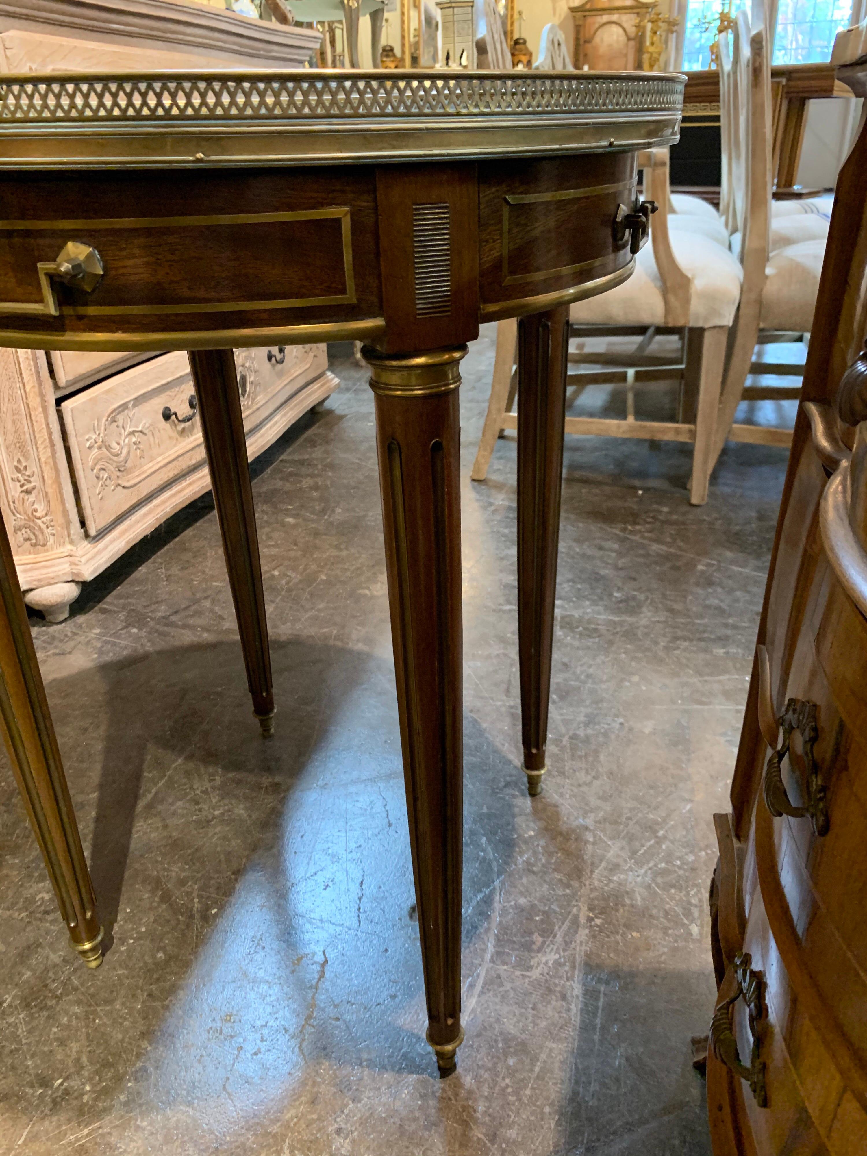 Beautiful French Directoire style mahogany bouiliotte table with mirrored top. Lovely brass details on the legs, drawers and top. A Classic table that makes a sophisticated statement!