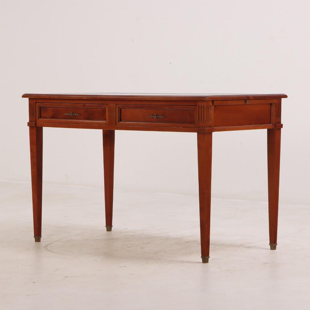 French Directoire style mahogany leather top writing desk C 1940. This desk has a black leather top with gold embossing over two drawers and two leather covered writing slides. One key included.