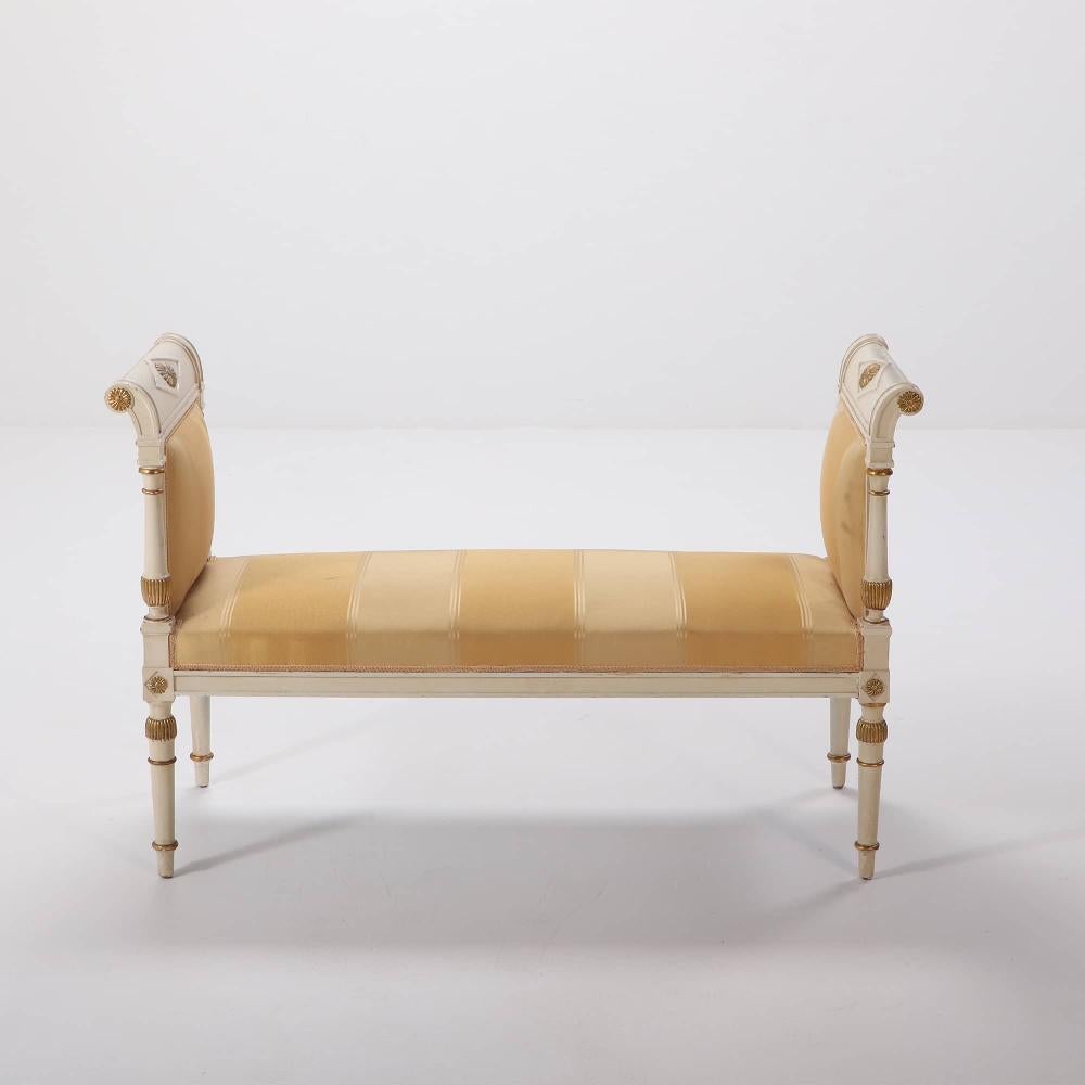 French Directoire style painted and gilt window bench circa 1950 having carved columns and rolled ends.