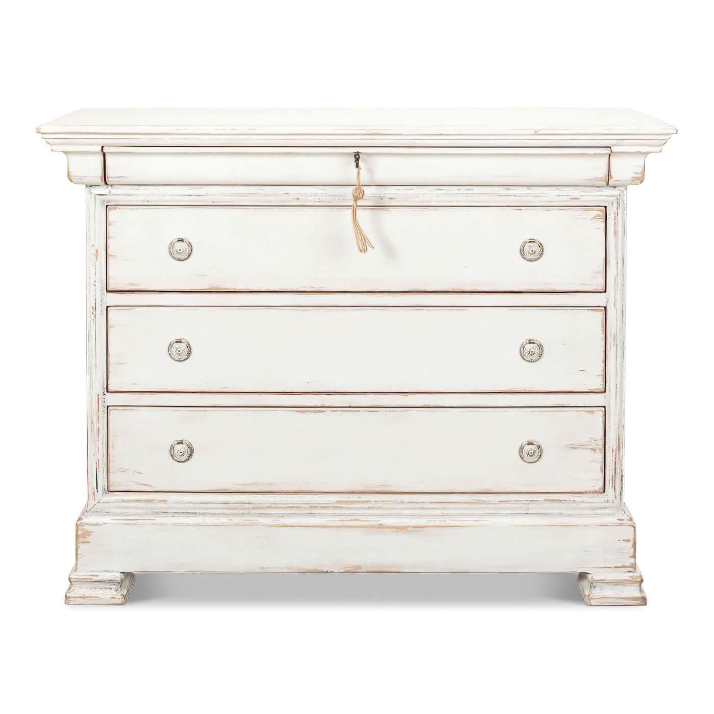 A French Directoire-style commode with an antiqued whitewash finish. This beautiful piece has four drawers with ring pulls, the top drawer is keyed. It's crafted from pine and has an architectural influence with its semblance of crown and base