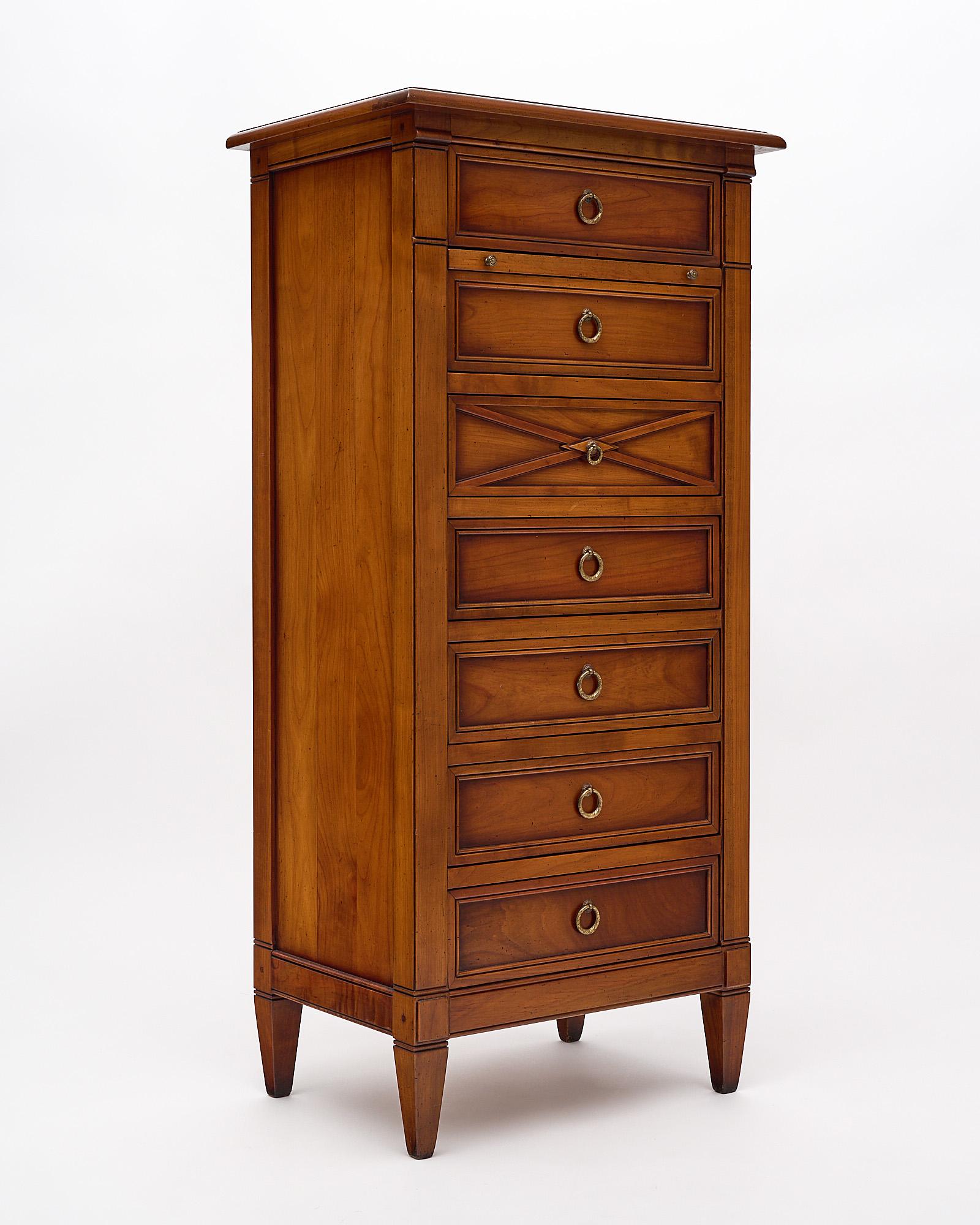 Semainier with seven dovetailed drawers (semaine means week in French) made of hand-carved cherry wood with tapered legs. This cabinet features an additional pull out shelf.