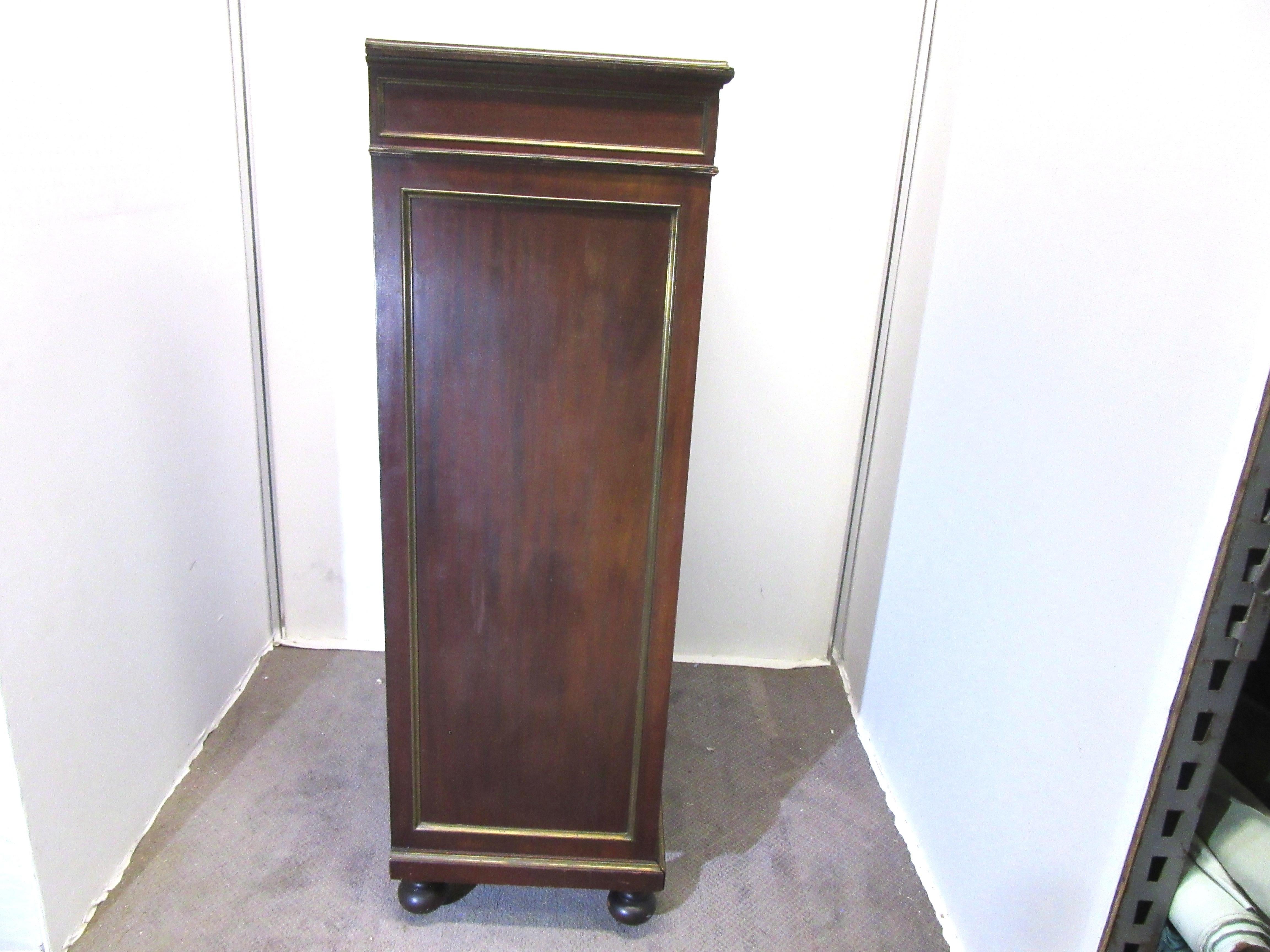 French Directoire style mahogany and brass banded semainier chest. In a high size with bulbous feet, seven drawers and original brass pulls. Made during the 1940s in France, the piece is in great vintage condition with age-appropriate wear and use.