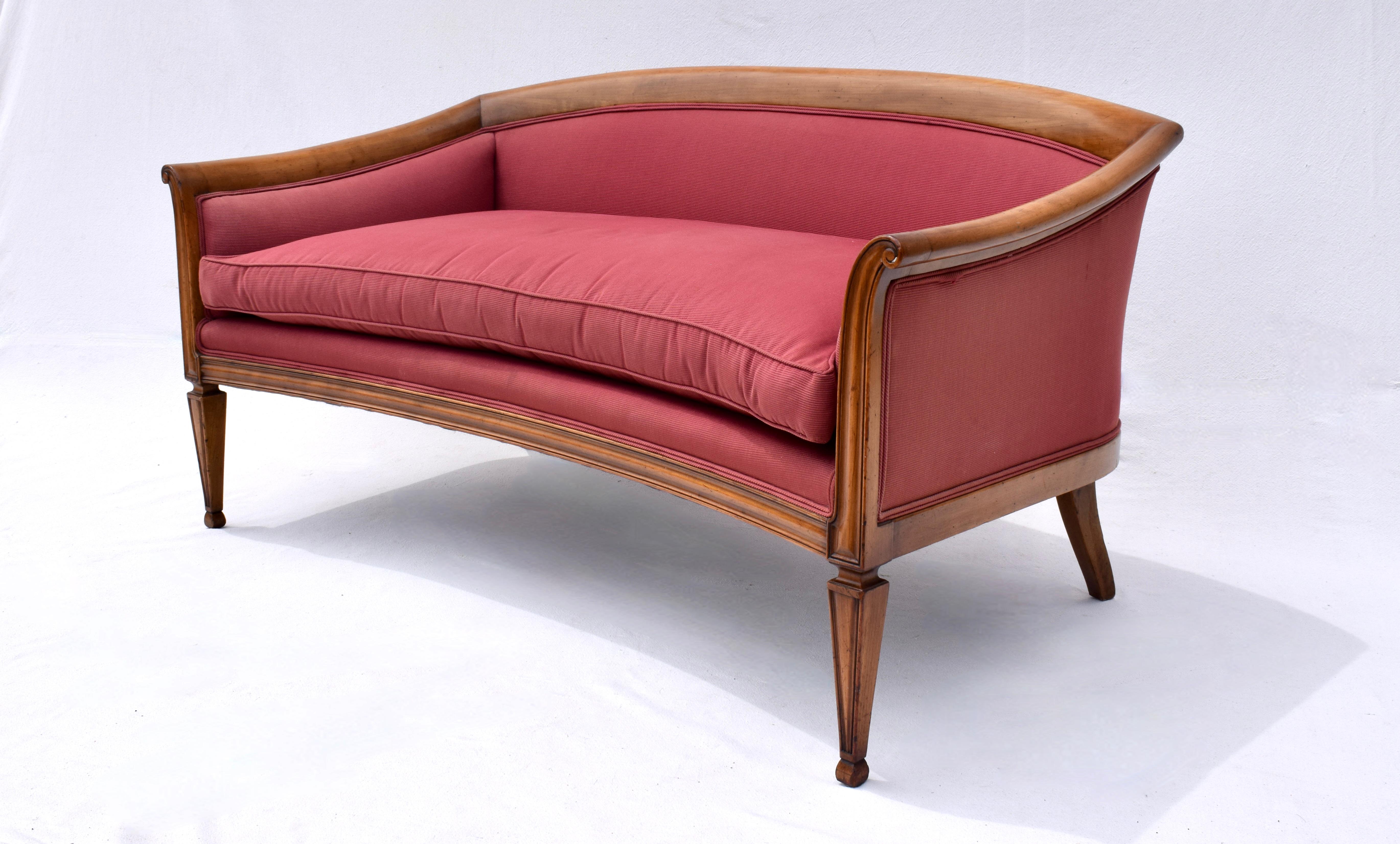 Canapé en merisier massif de style Directoire français avec des accoudoirs subtilement enroulés et des pieds effilés à l'avant et évasés à l'arrière. Un canapé de transition unique qui peut être placé dans une variété d'endroits grâce à ses