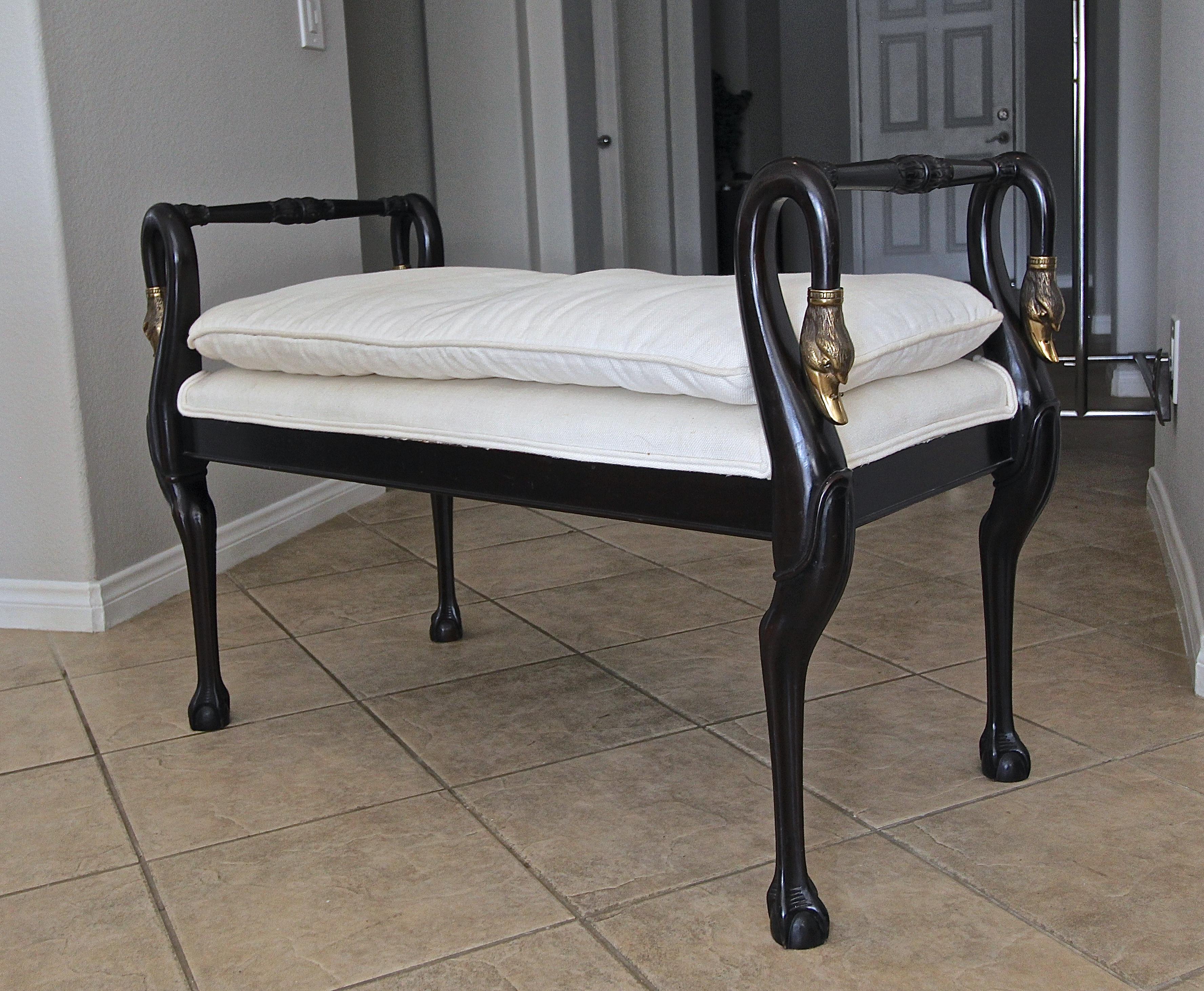 Directoire style wood and brass bench with swan head mounts and paw feet motif. Handmade made with carved legs and armrests. Wood finish is an ebony (very dark brown) and is upholstered in a white canvas textured fabric, top cushion is removable. 
