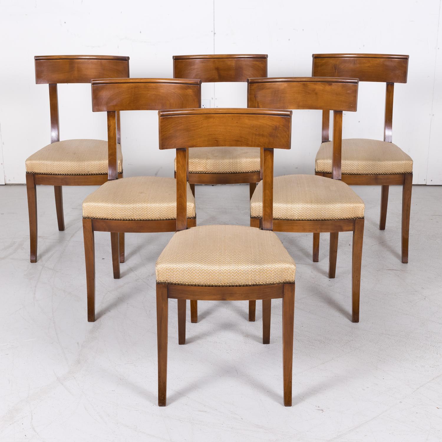 Set of six vintage French Directoire style side chairs handcrafted of walnut, circa 1970s. These Neoclassical dining chairs feature a tailored look with a curved, wraparound back rail and a generous, comfortable seat with a curved front above a