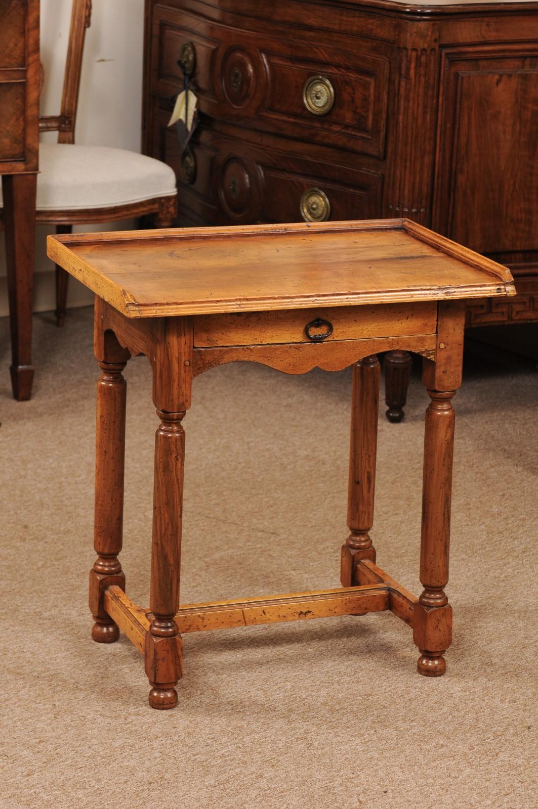 The late 19th century Directoire style walnut side table with tray top, drawer below with ring pull, shaped apron, turned legs joined by H-form stretcher ending in rounded feet.

    