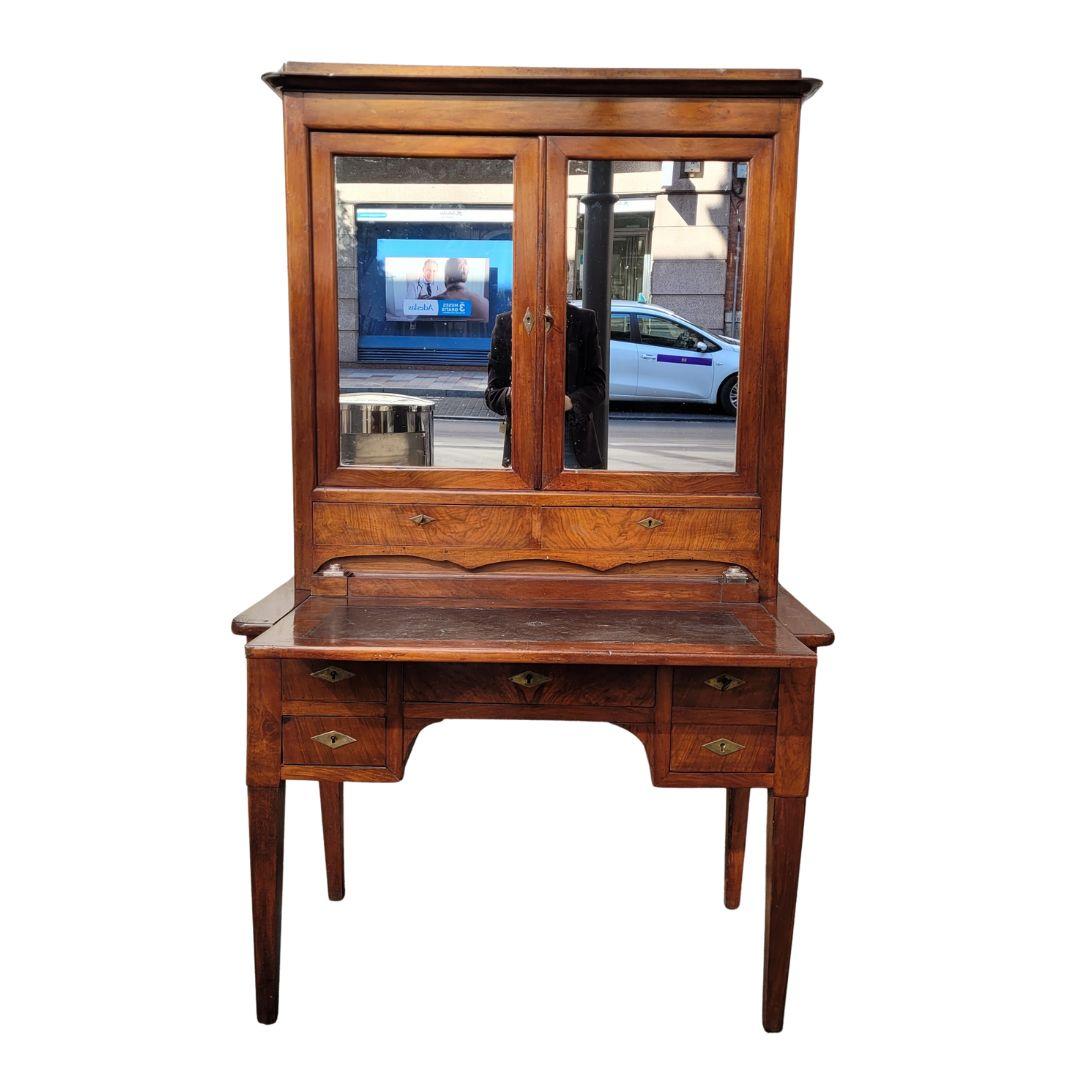 Splendida scrivania o bureau francese in mogano Bonheur du Jour, risalente agli inizi del XIX secolo, con piano in pelle e ante superiori a specchio.

Il pezzo, interamente realizzato in un bellissimo legno di mogano, poggia su quattro gambe dritte