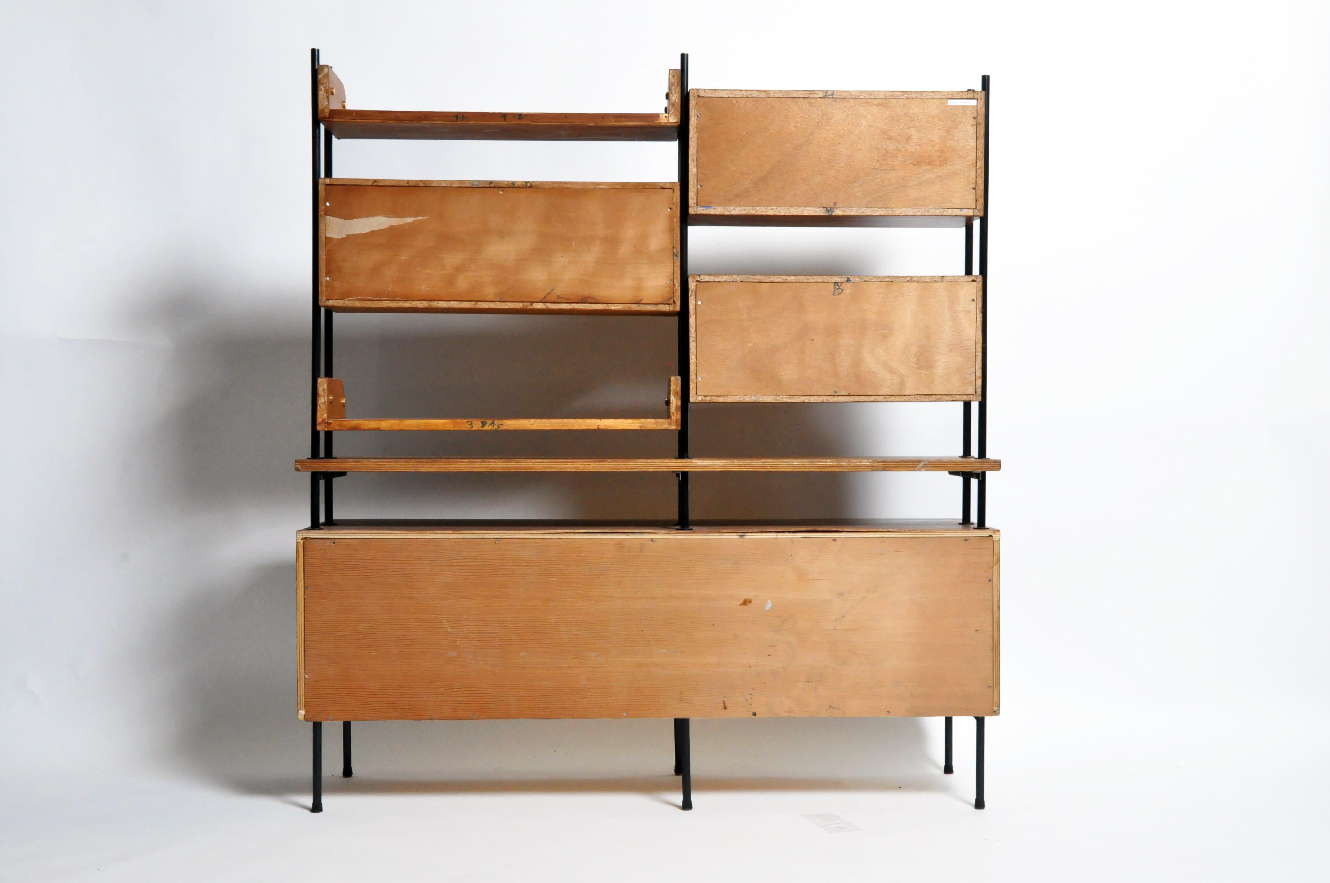 Sideboard and bookshelf with asymmetrical storage units and sliding doors. Mahogany veneers with yellow lacquer. The frame is metal. Wear consistent with age and use.