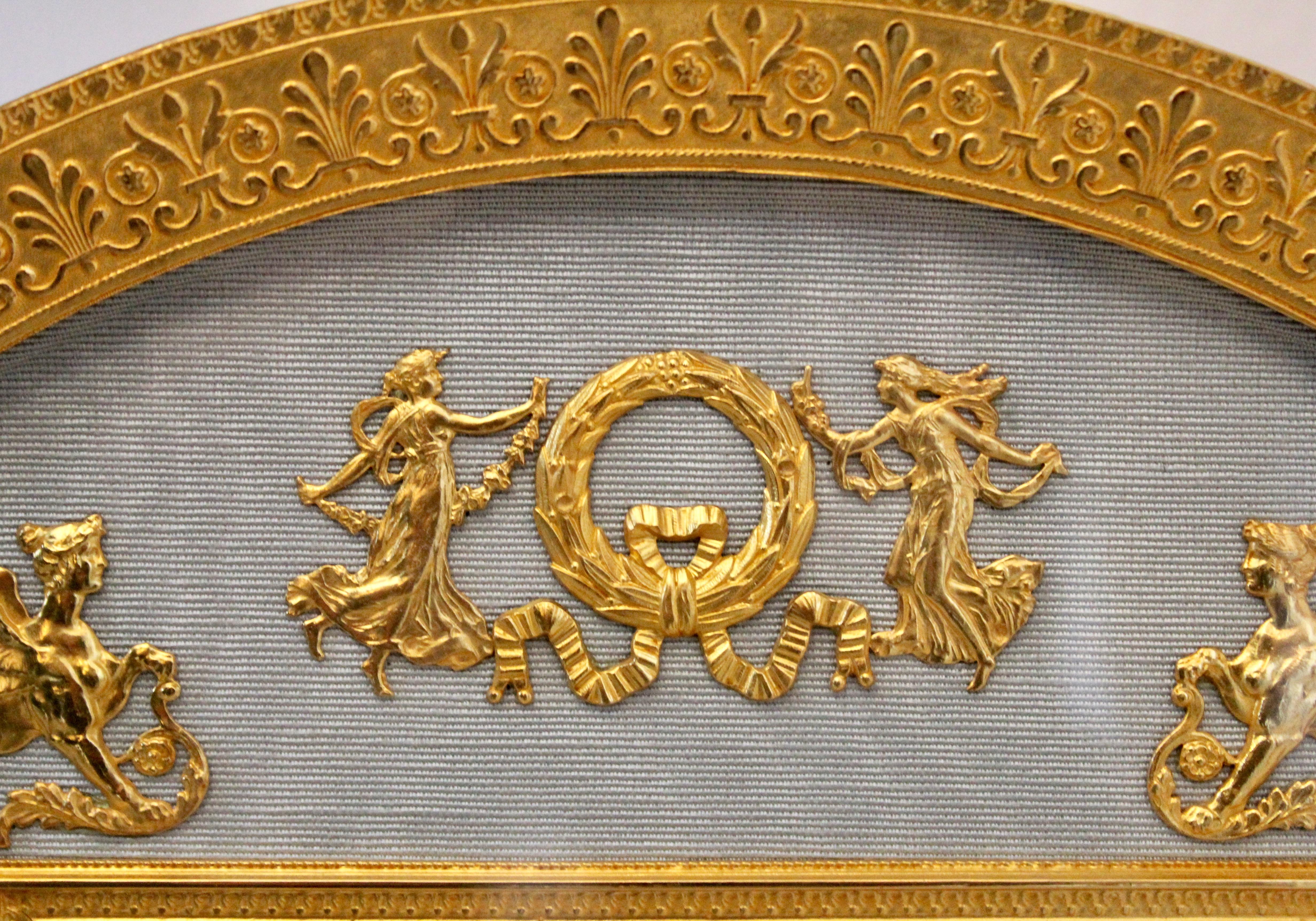 French domed top rectangular ormolu Empire style photo frame circa 1900. The ormolu border with continuous palmate motif framing the blue silk slip, upon which classical motifs such as wreaths and female griffins, also in ormolu are applied.