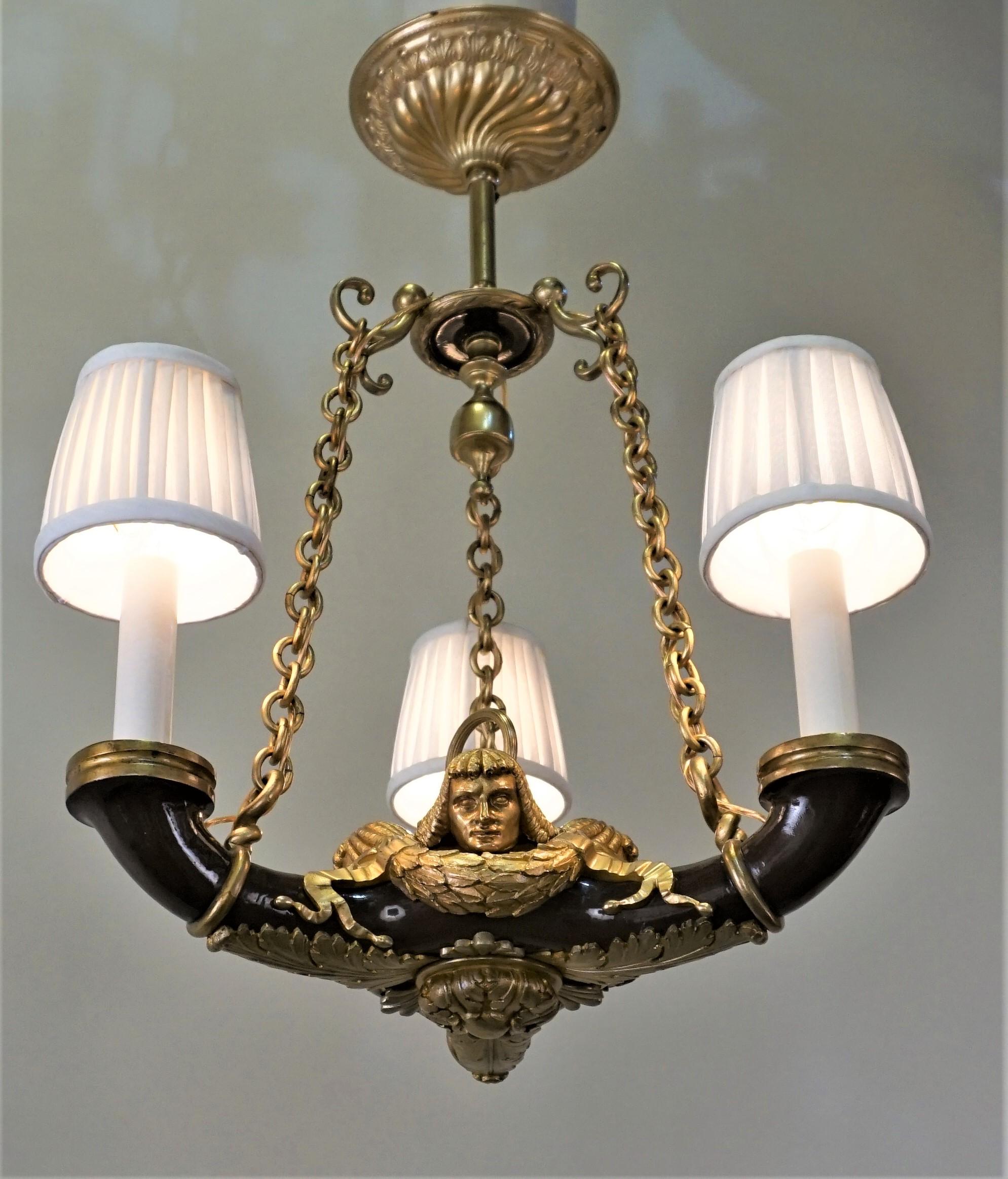 French 1910s three lights doré bronze and lacquer Empire style chandelier.
Fitted pleated silk lampshades
Measurement is without lampshades.