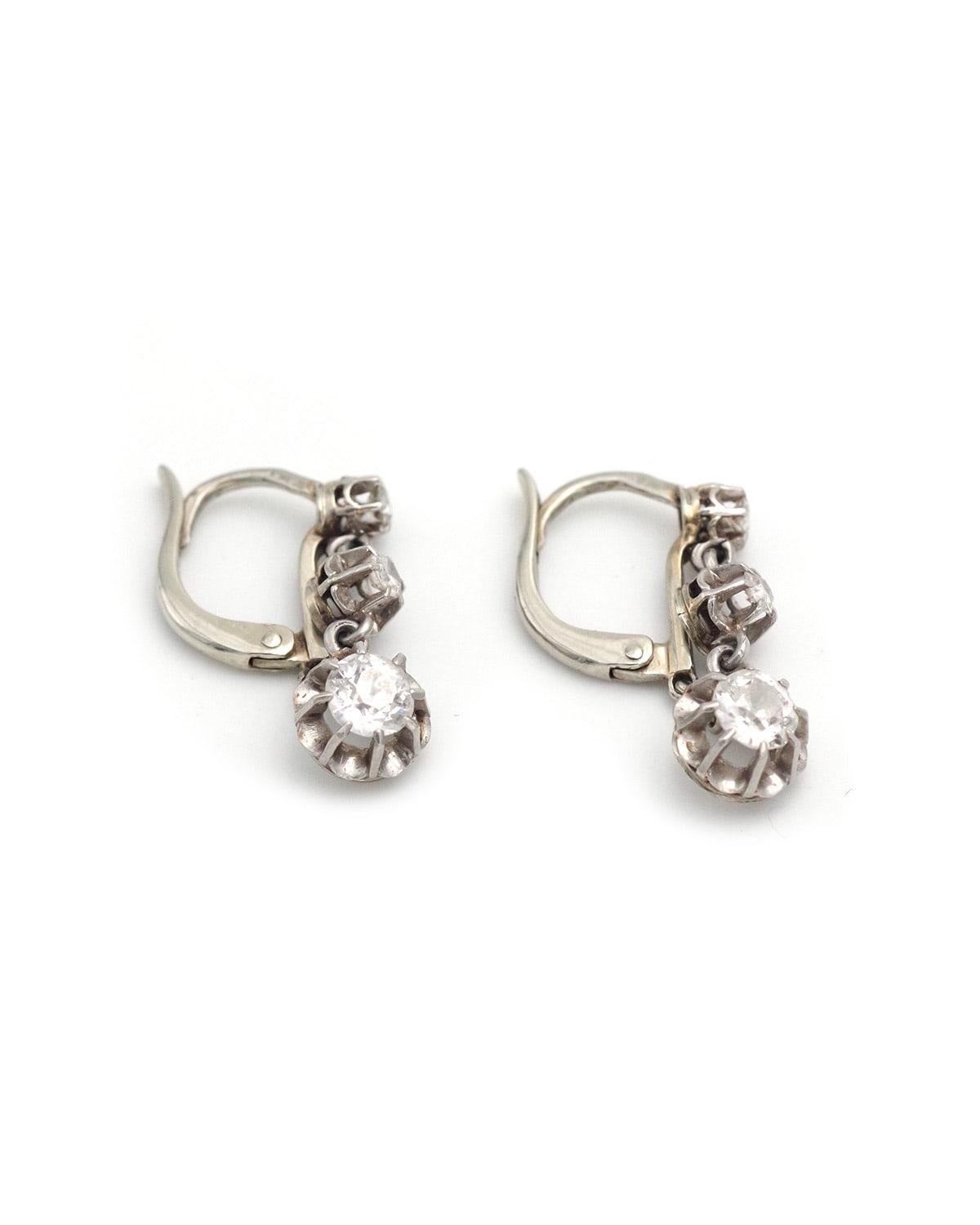 Edwardian three diamonds dormeuses earrings 0.72 ct in 18 karat gold and platinum from the Art Deco period. Composed of three parts, set with diamonds, the main diamond, old mine cut, weighs 0.30 ct. The closure system attaches to the front of the