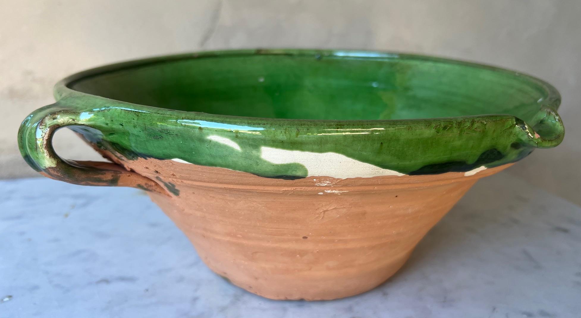 French vintage confit /tian bowl made in France around the 1970's.  The bowl is made of terra cotta and painted a vibrant green glaze, with two handles and a spout.